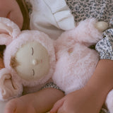 A close of a child cuddling the Olli Ella Pink Bunny Moppet Lullaby Cozy Dinkum.