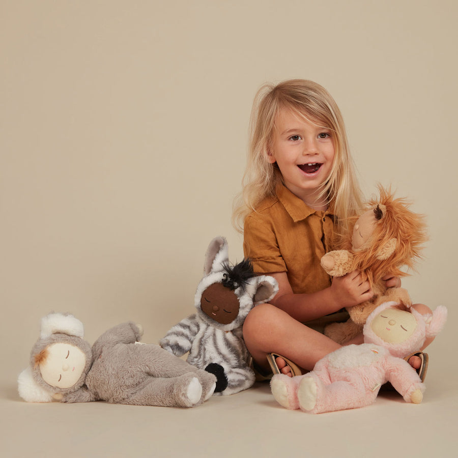 Child holding the Olli Ella Lion Pip Cozy Dinkum Doll with the Koaloa