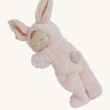 The Olli Ella Pink Bunny Moppet Lullaby Cozy Dinkum on a plain background. The doll is laying on it's front showing the bunny tail on the back. 