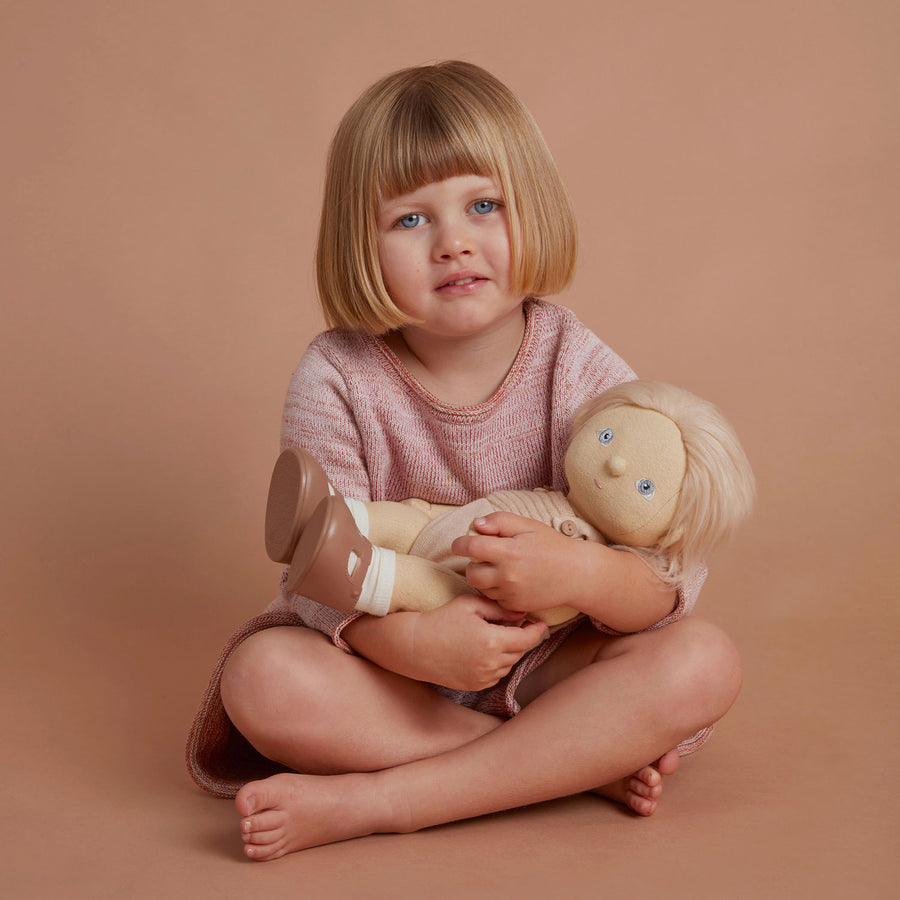 Dinkum Doll sitting down pictured on a plain coloured background