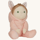 Olli Ella pink coloured Babbit Bunny Dinky Dinkum Doll in a seated position, the bunny ear hood has been pulled down showing the dolly's blond coloured hair.