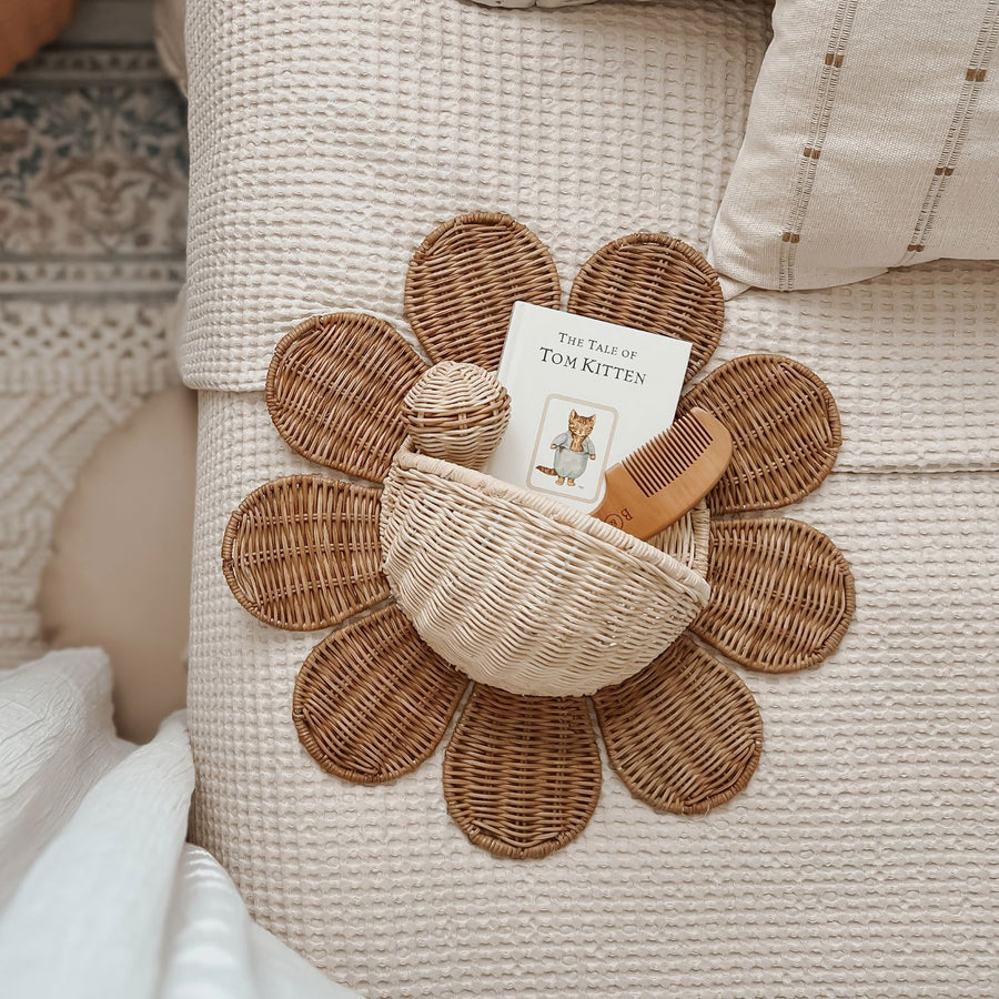 The Olli Ella Rattan Daisy Wall Basket in Natural Rattan on a bed