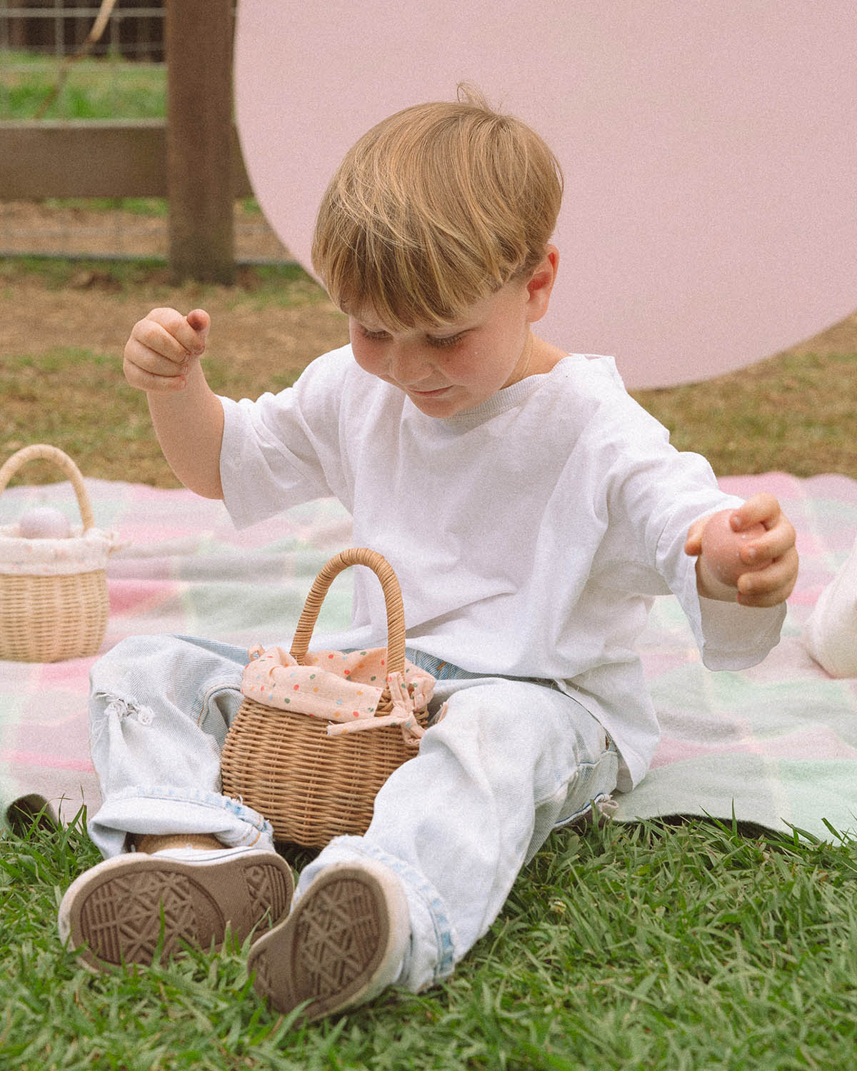 A child holding the Olli Ella Rattan Berry Basket with Lining – Gumdrop