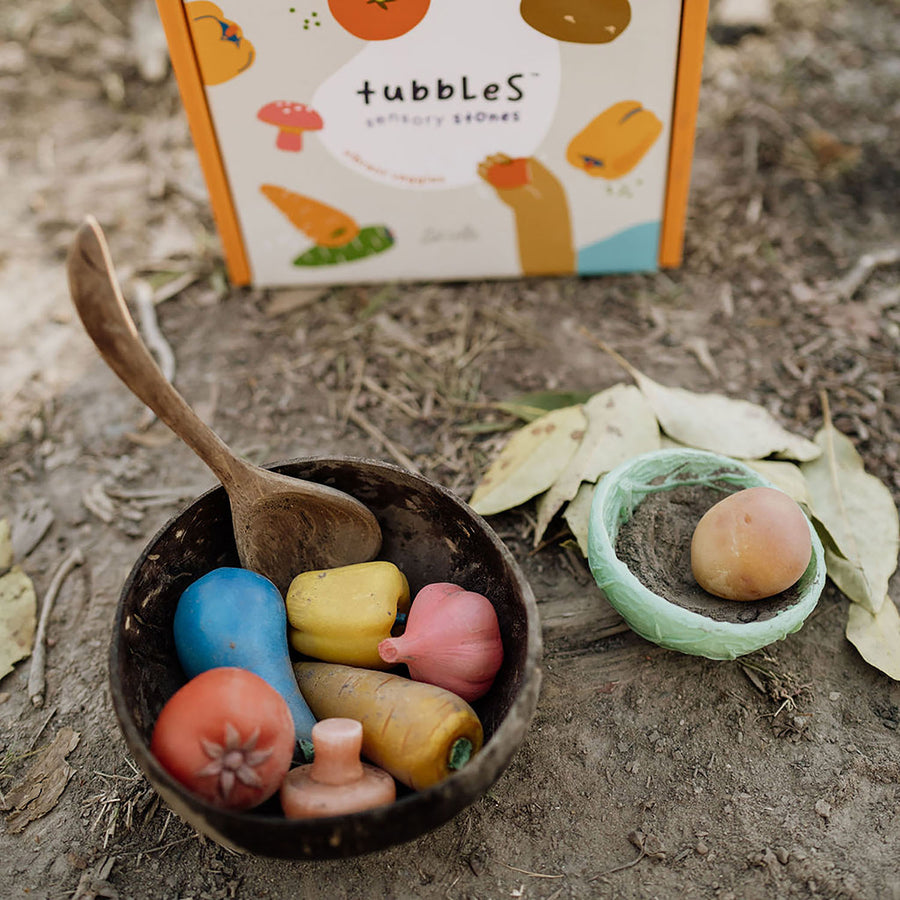 Olli Ella tubble stones being used in play with a wooden spoon and bowl