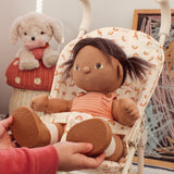 An Olli Ella Dottie Dinkum doll in a seated position in a toy pushchair. 