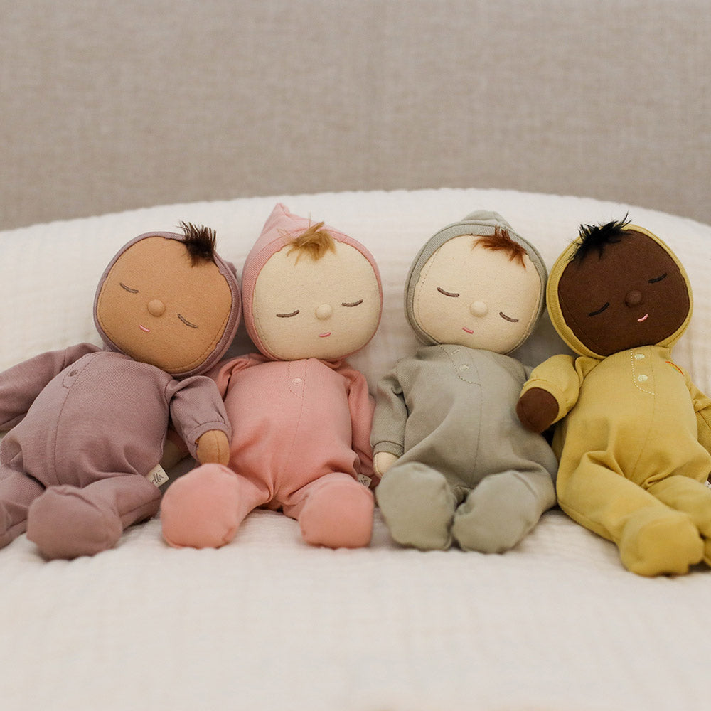 4 colours of the Olli Ella cotton Dozy Dinkum dolls laying in a line on a white bed