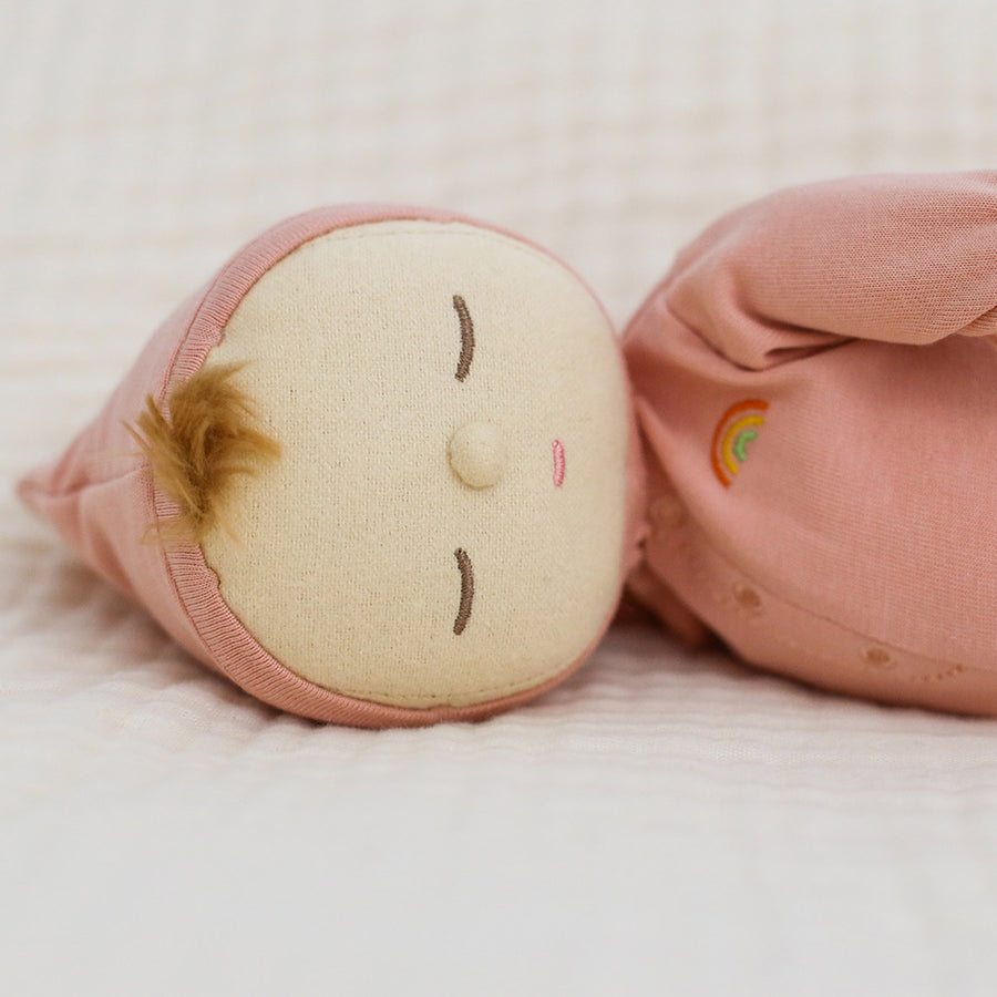 Close up on the face of the Olli Ella Dozy Dinkum doll laying on a white background