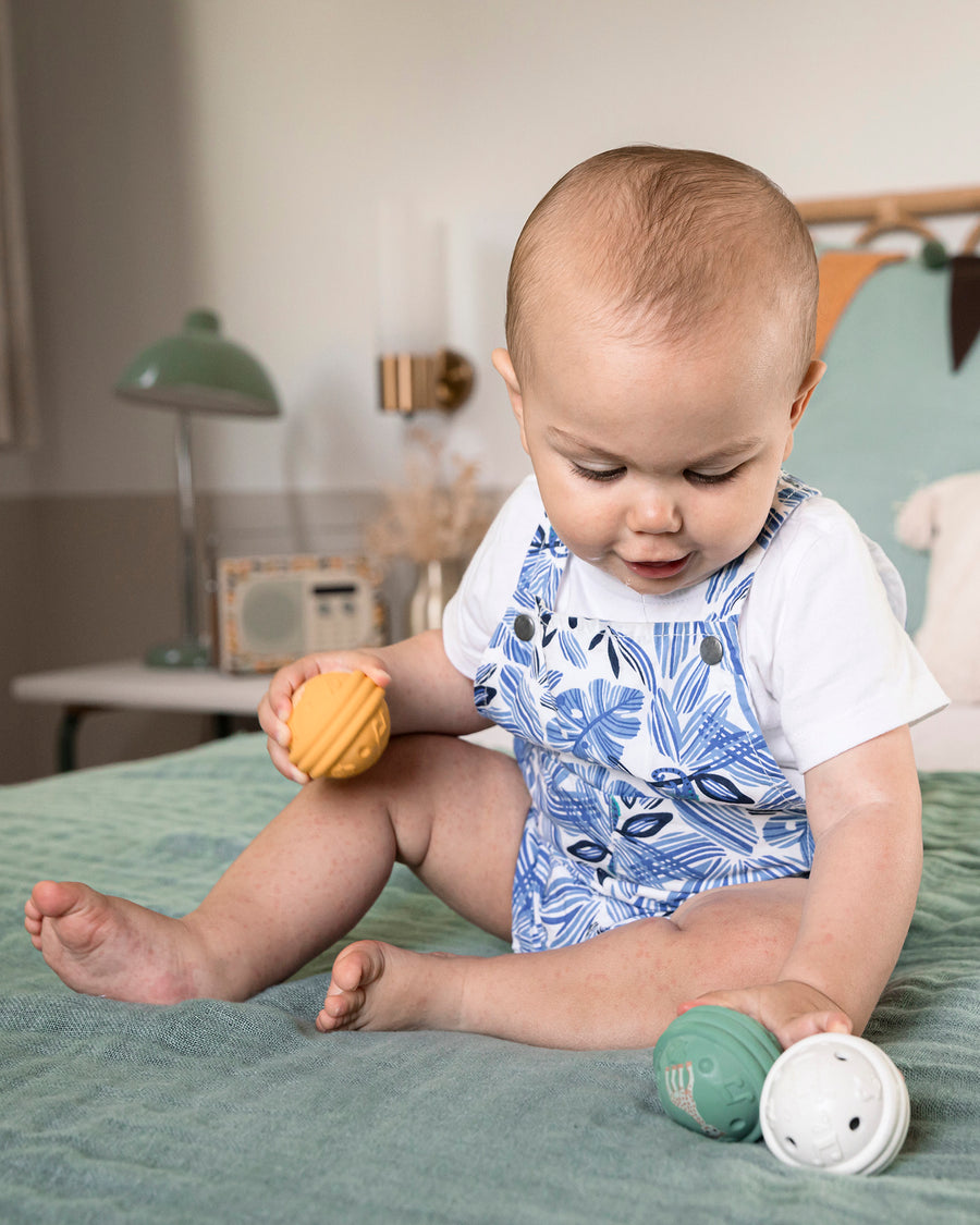 A child sat on a green bed sheet