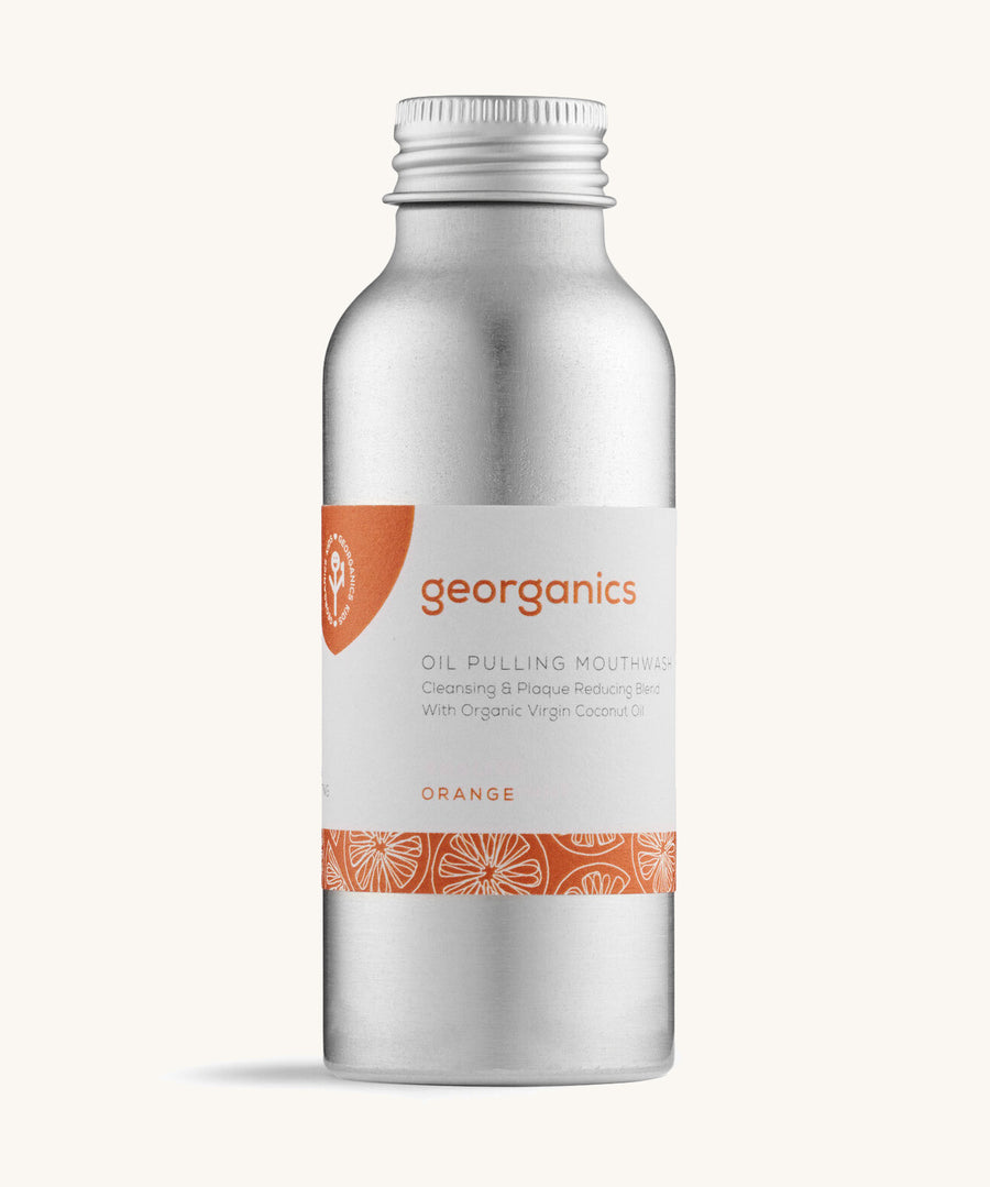 A bottle of the Georganics orange oil pulling mouthwash on a cream background