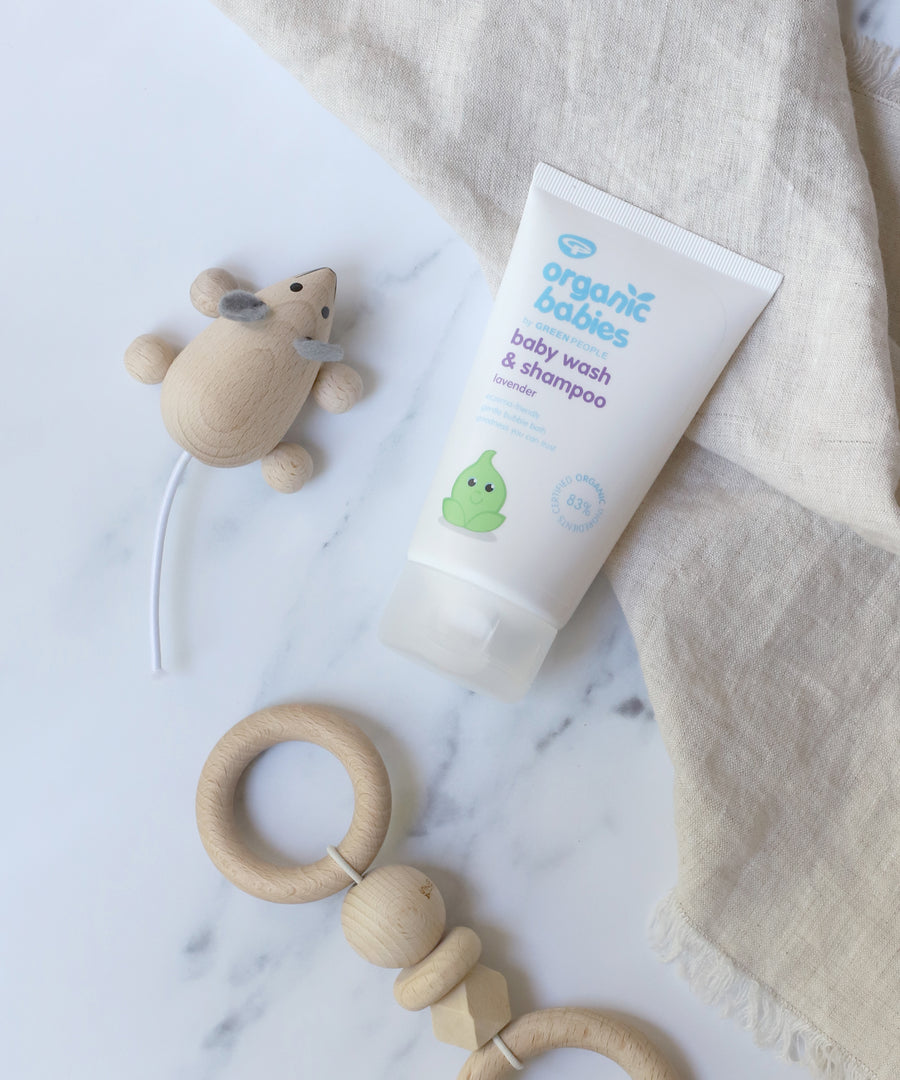 Organic Babies Baby Wash & Shampoo Lavender on a marble surface next to a wooden toy mouse and teething toy.