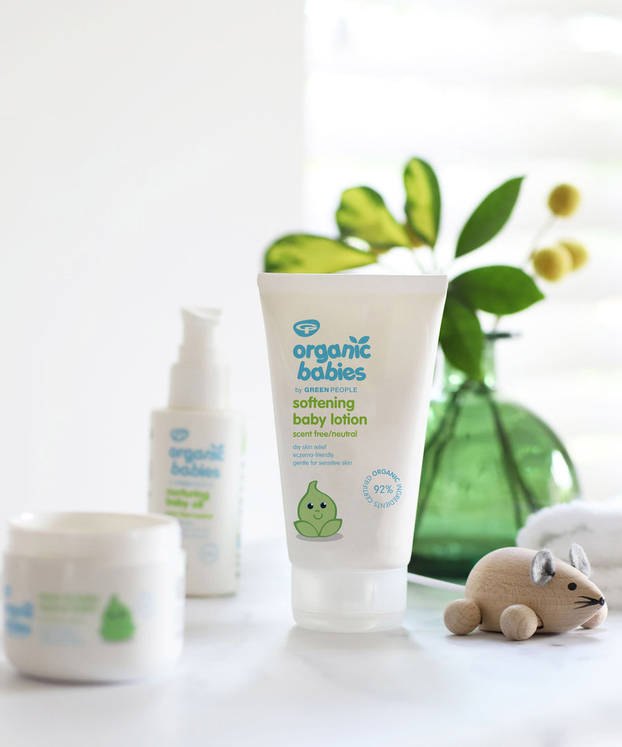 Organic Babies Softening Baby Lotion 150ml in front of a green vase with leaves in. 