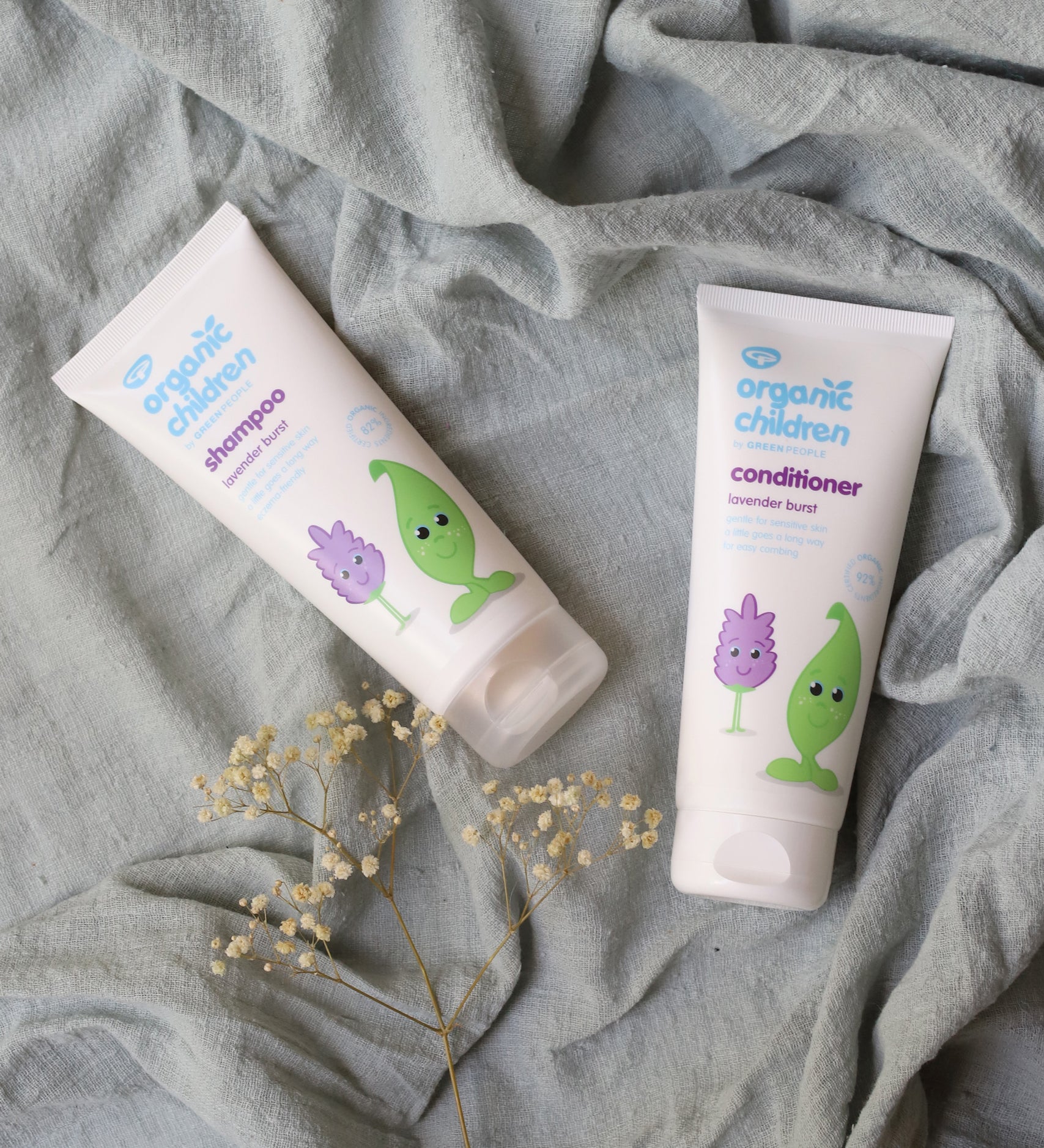 Organic Children Lavender Burst Shampoo and conditioner on a piece of moss green coloured linen. 