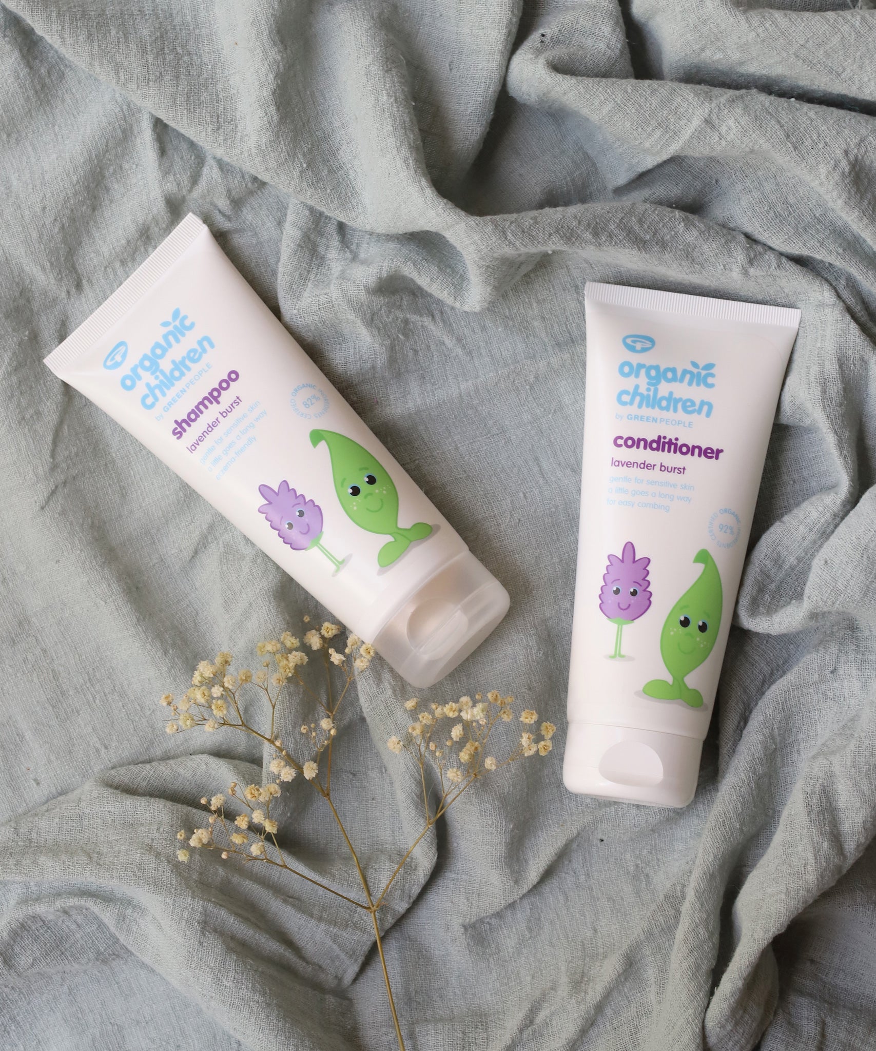 Organic Children Lavender Burst Shampoo and conditioner on a piece of moss green coloured linen. 