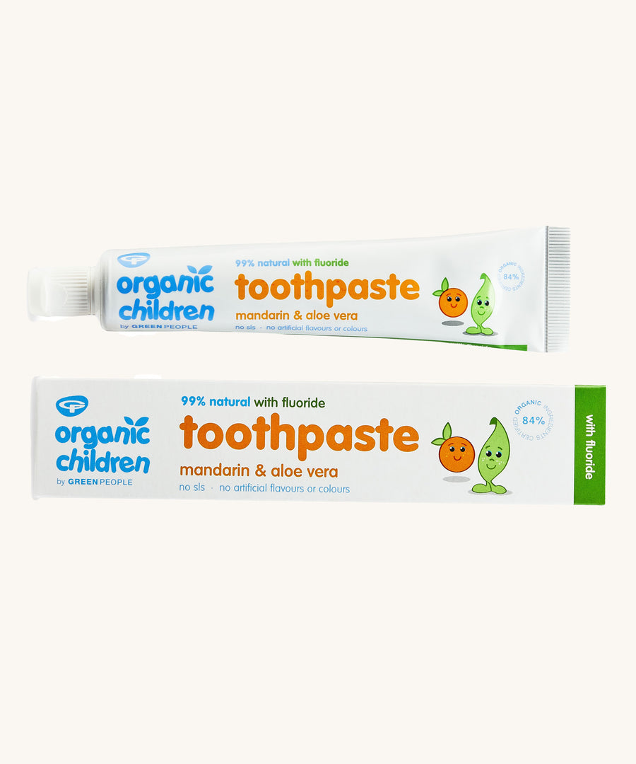 Organic Children Toothpaste Mandarin & Aloe Vera with Fluoride showing the tube next to the cardboard on a plain background. 