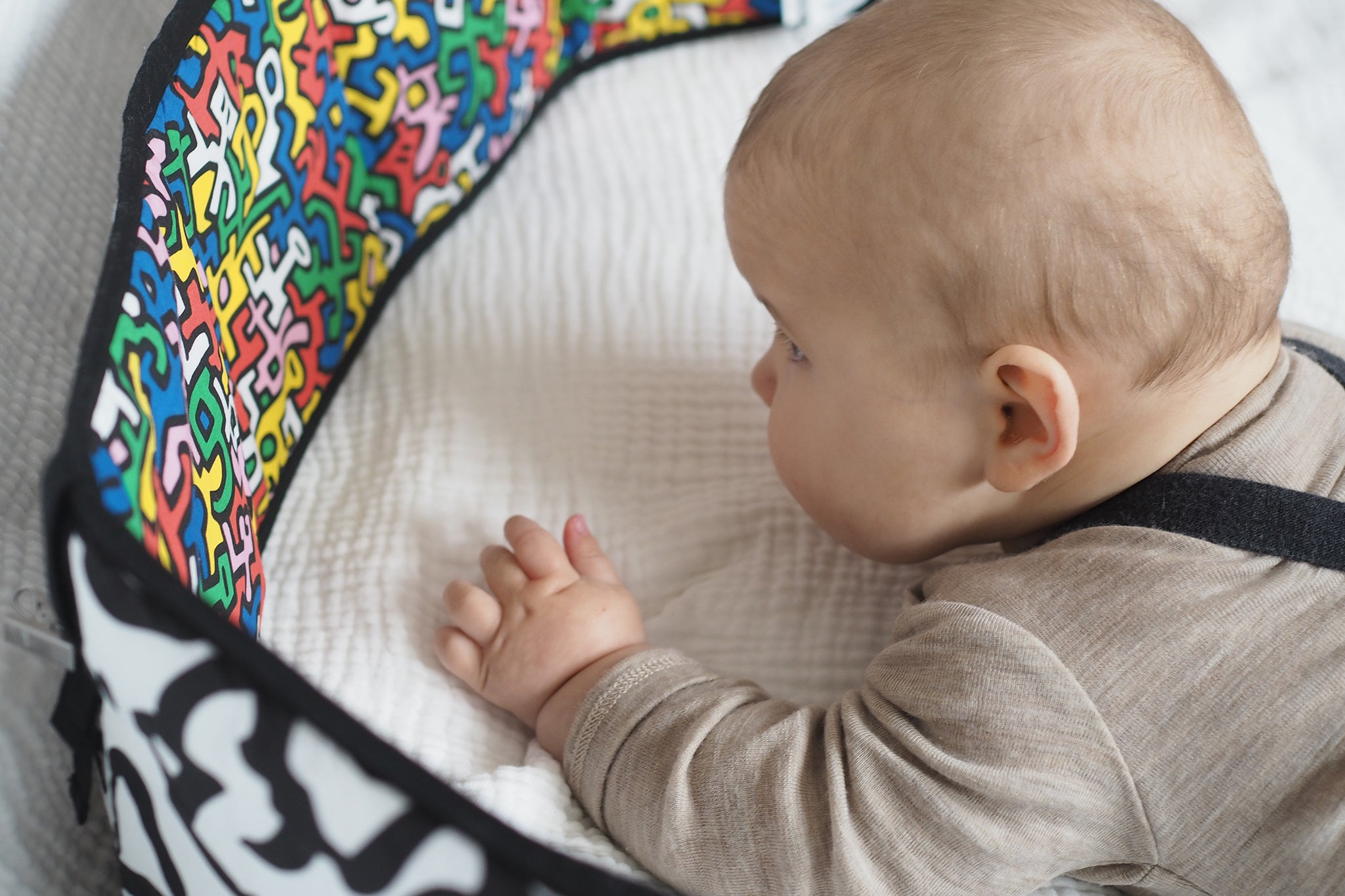 A child look at the 'Baby' print on the Etta Loves X Keith Haring Reversible Baby Sensory Strip