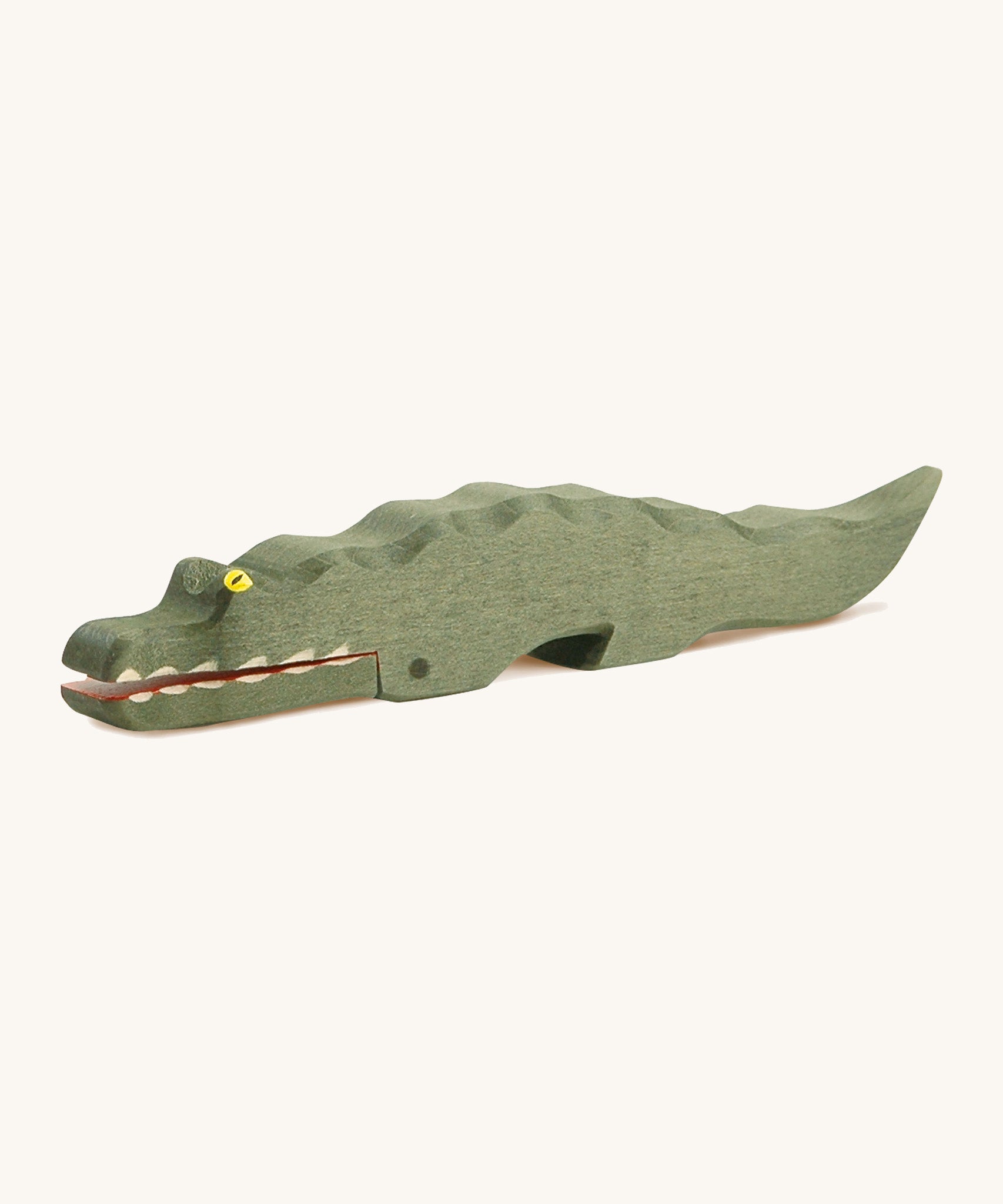 A wooden Ostheimer crocodile figure on a cream background.