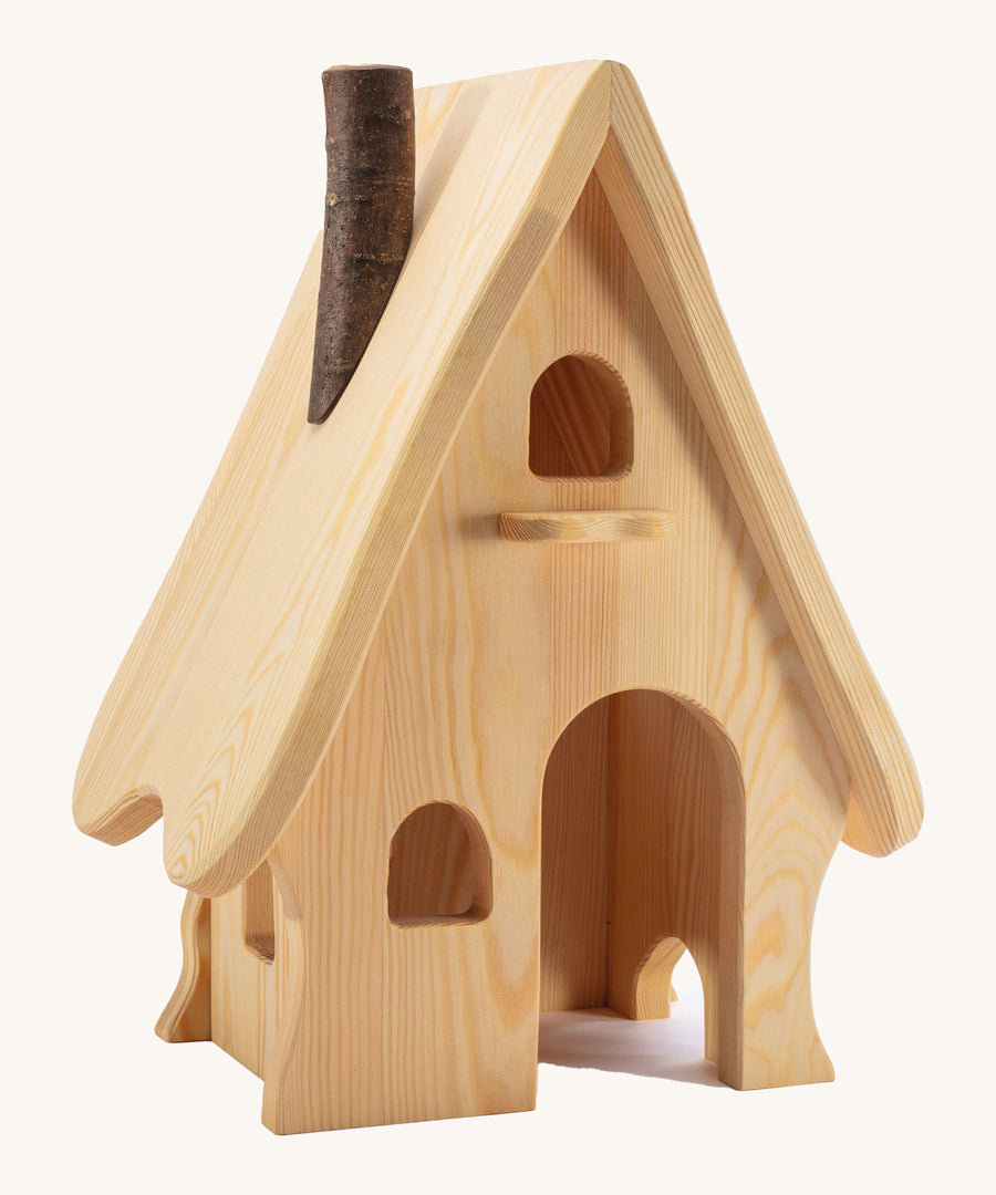 A wooden Ostheimer fairy tale dolls house on a cream background.