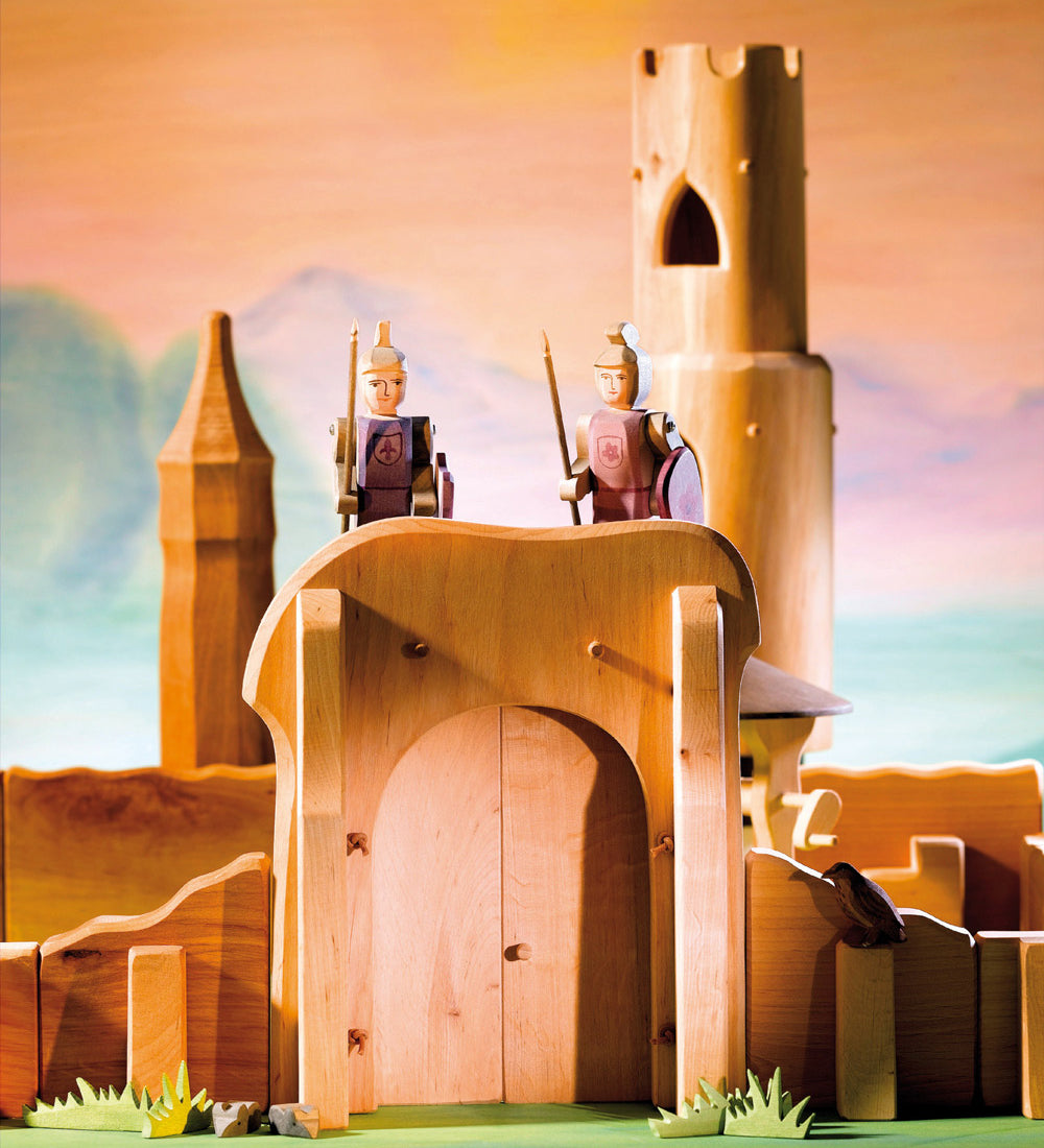 Close up of some Ostheimer toy knights stood on top the small world castle gates toy set