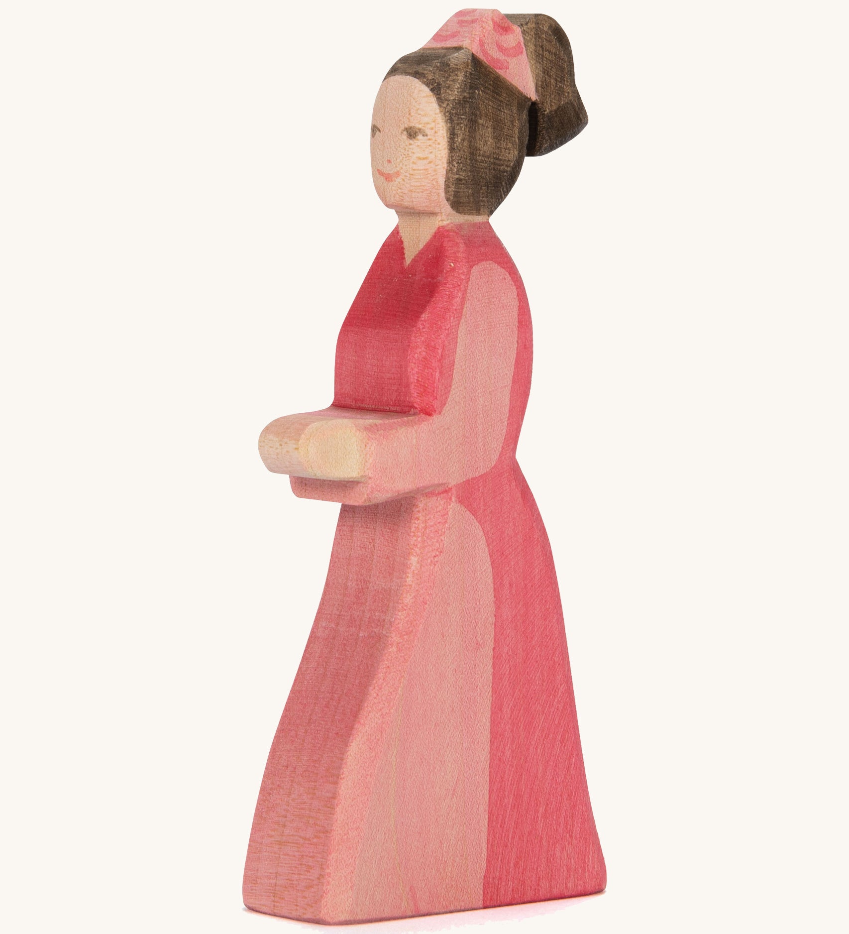 A pink lady in waiting wooden figure on a cream background