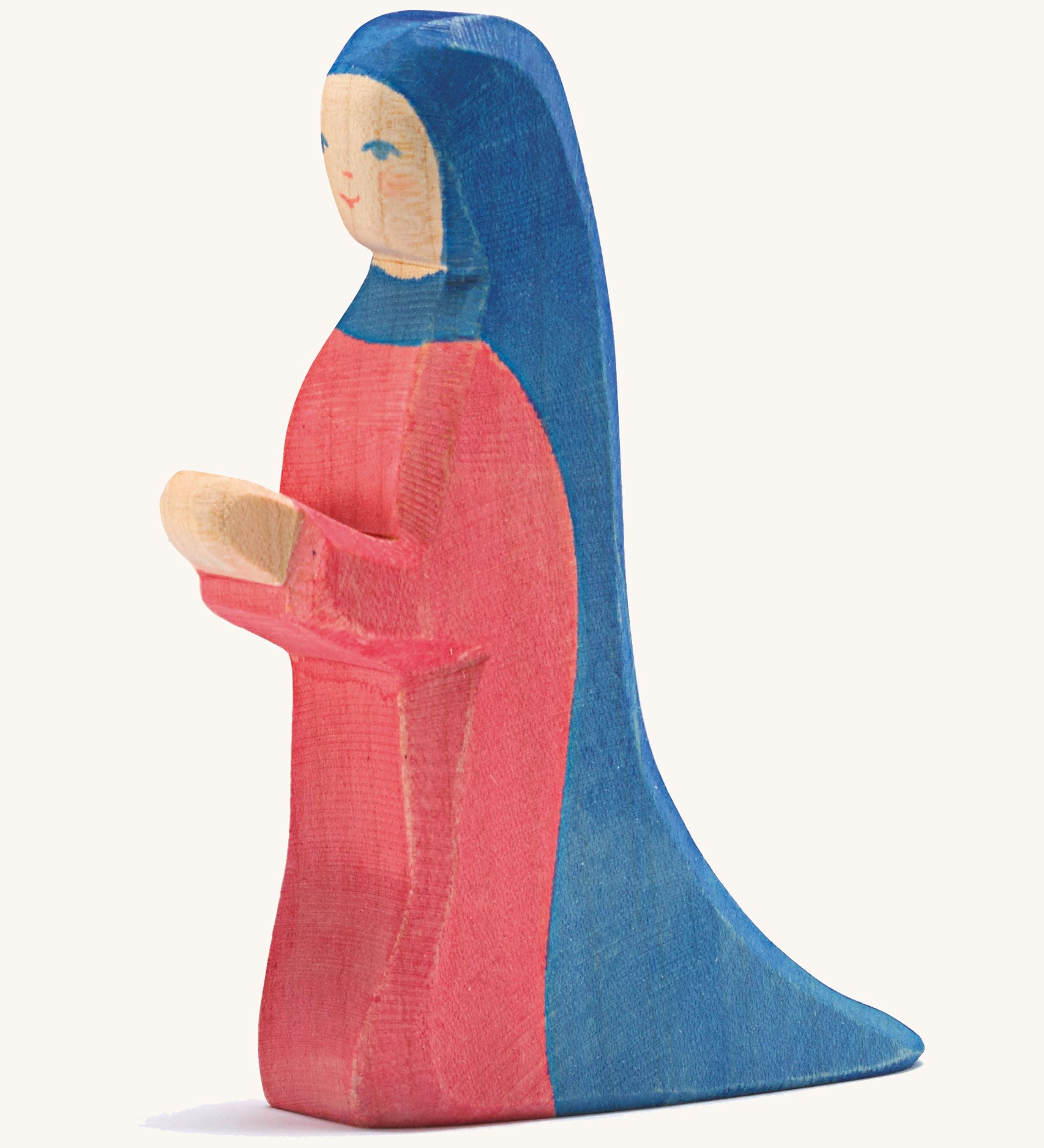 A wooden kneeling Mary figure on a cream background