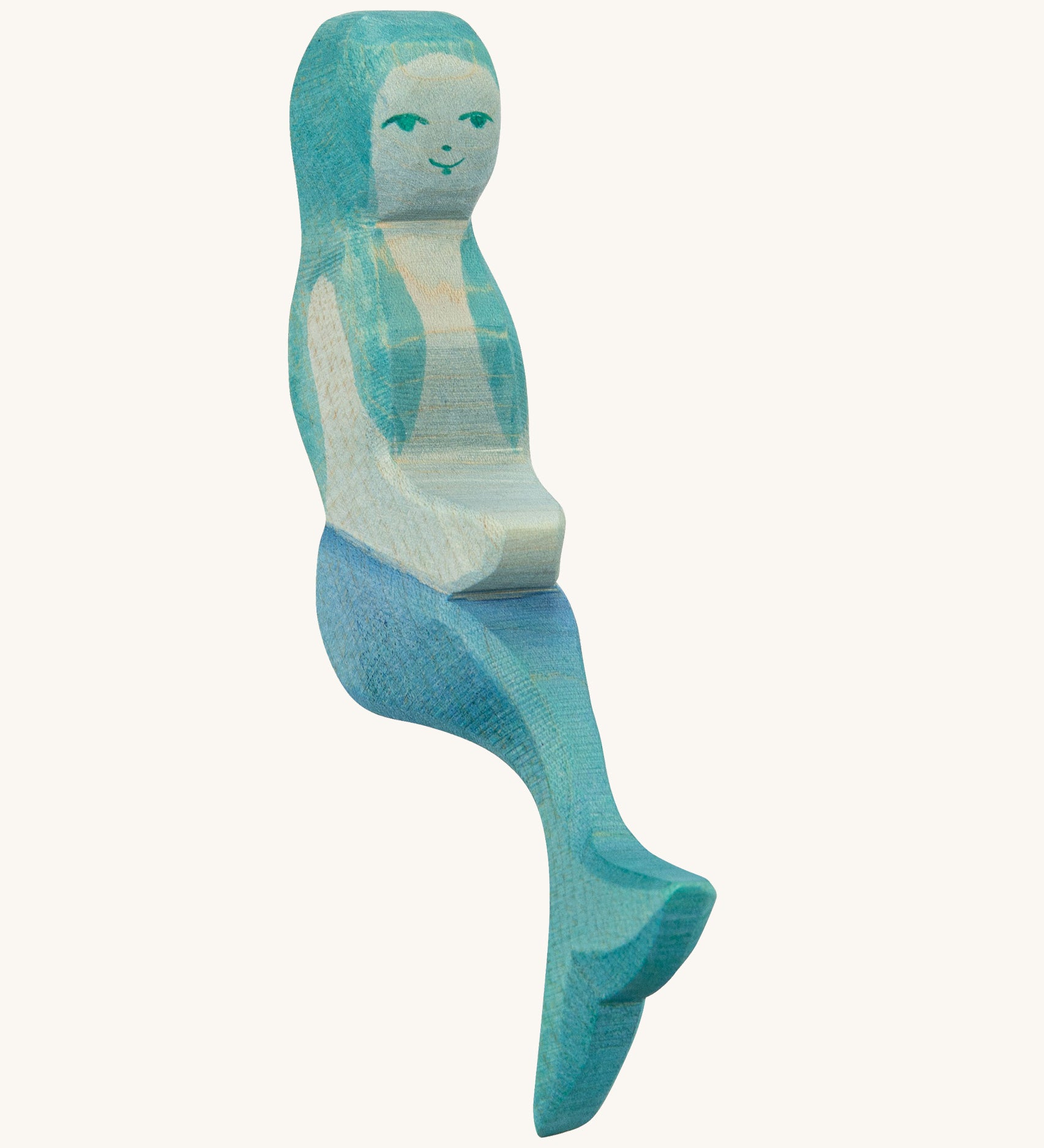 A wooden sitting Ostheimer mermaid with blue hair on a cream background.