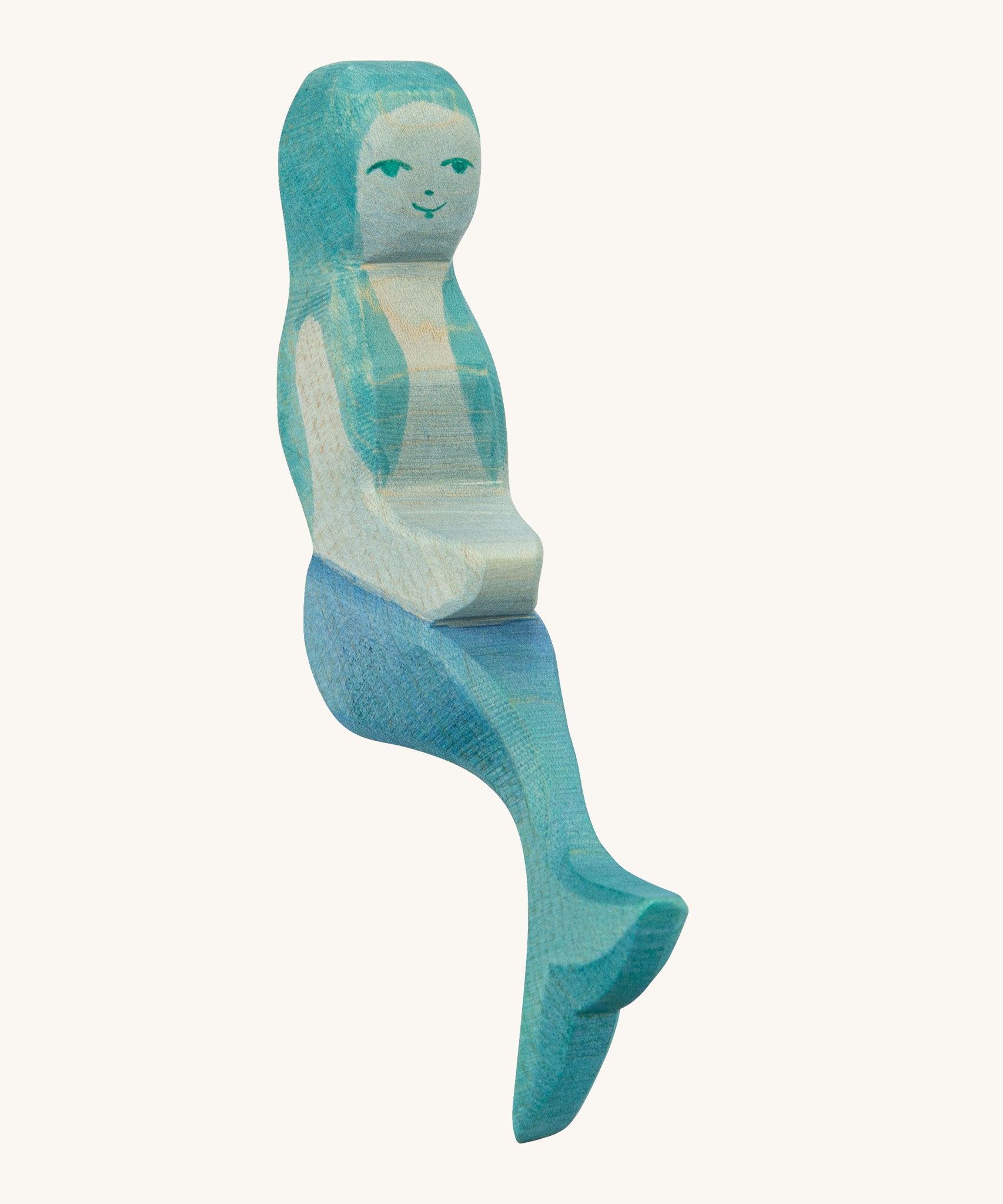 A wooden sitting Ostheimer mermaid with blue hair on a cream background.