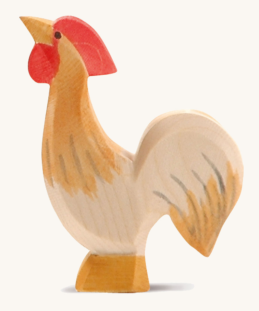 A ochre wooden Ostheimer rooster figure on a cream background.