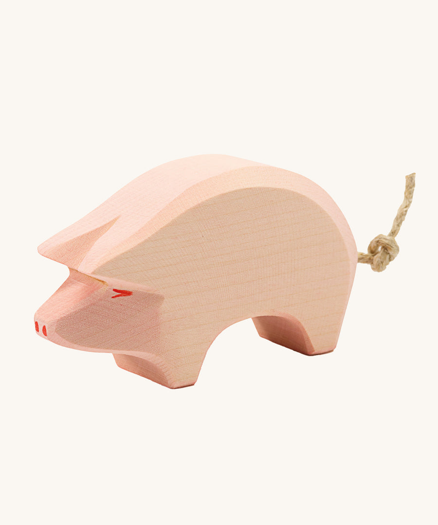 Ostheimer Pig toy figure with it's head held down low on a plain background. 