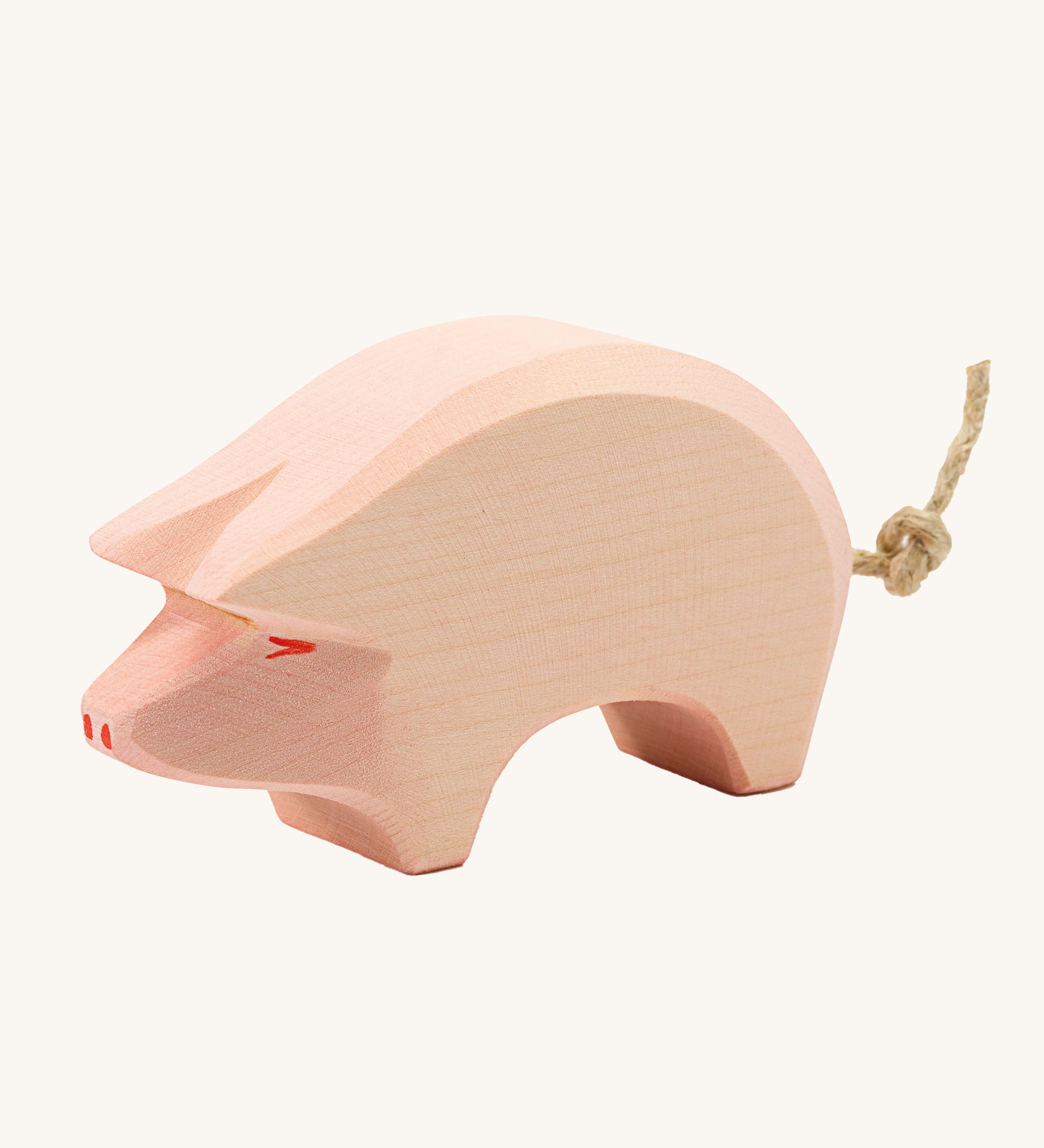 Ostheimer Pig toy figure with it's head held down low on a plain background. 