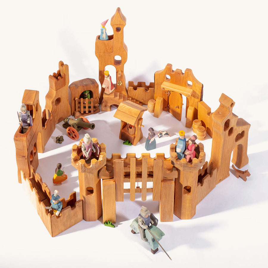 Ostheimer handmade wooden castle toy set laid out on a beige background