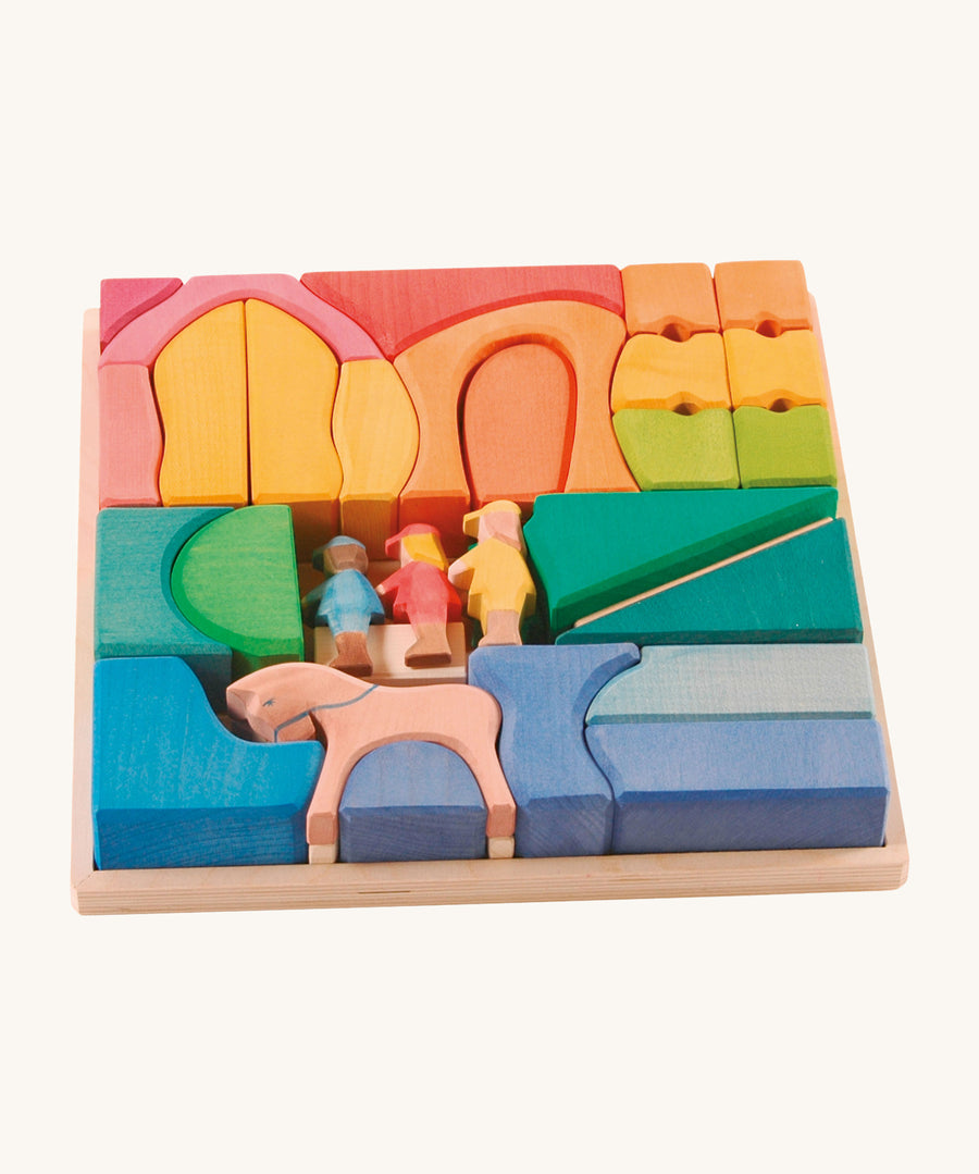 Ostheimer Rainbow Rider Farm wooden toy blocks set on a plain background. The blocks are placed in the wooden tray that they come with. 
