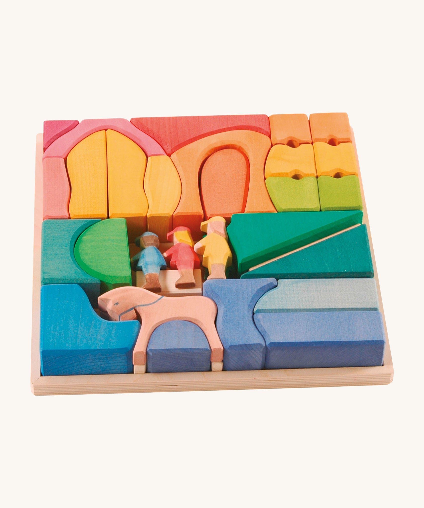 Ostheimer Rainbow Rider Farm wooden toy blocks set on a plain background. The blocks are placed in the wooden tray that they come with. 
