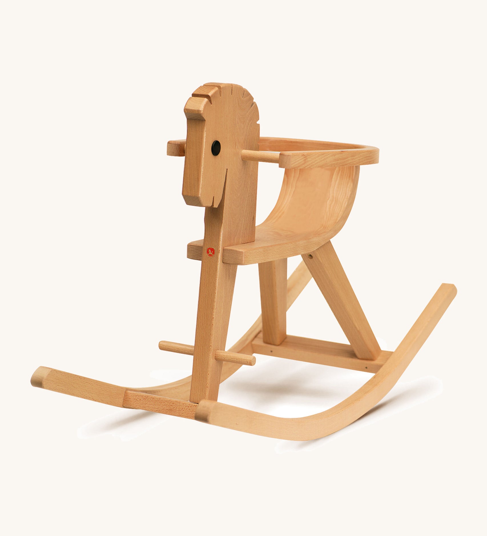 A different angle of the wooden rocking horse on a cream background