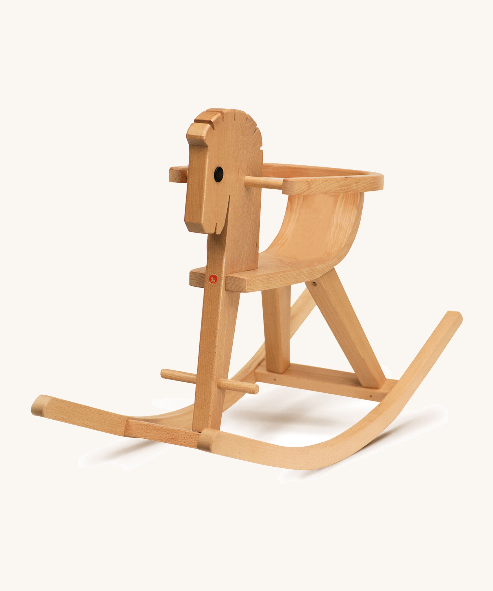 A different angle of the wooden rocking horse on a cream background