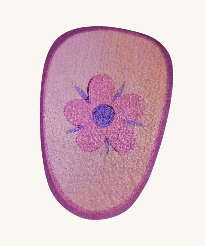 A pink wooden shield with a flower emblem on a cream background