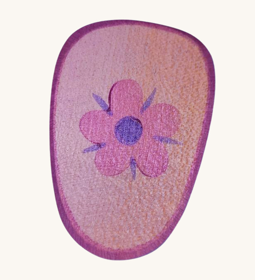 A pink wooden shield with a flower emblem on a cream background