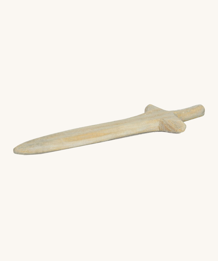 A short wooden sword lying flat on a cream background