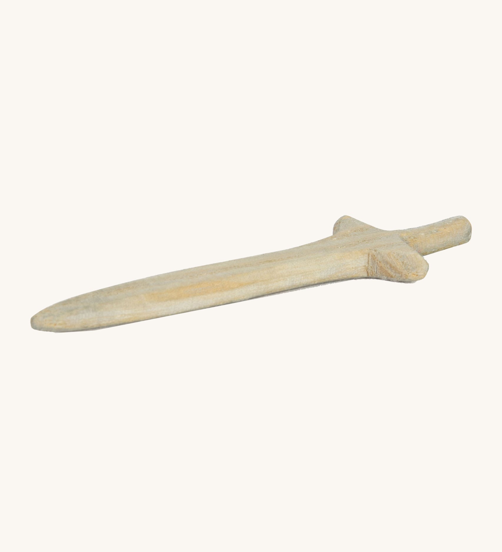 A short wooden sword lying flat on a cream background