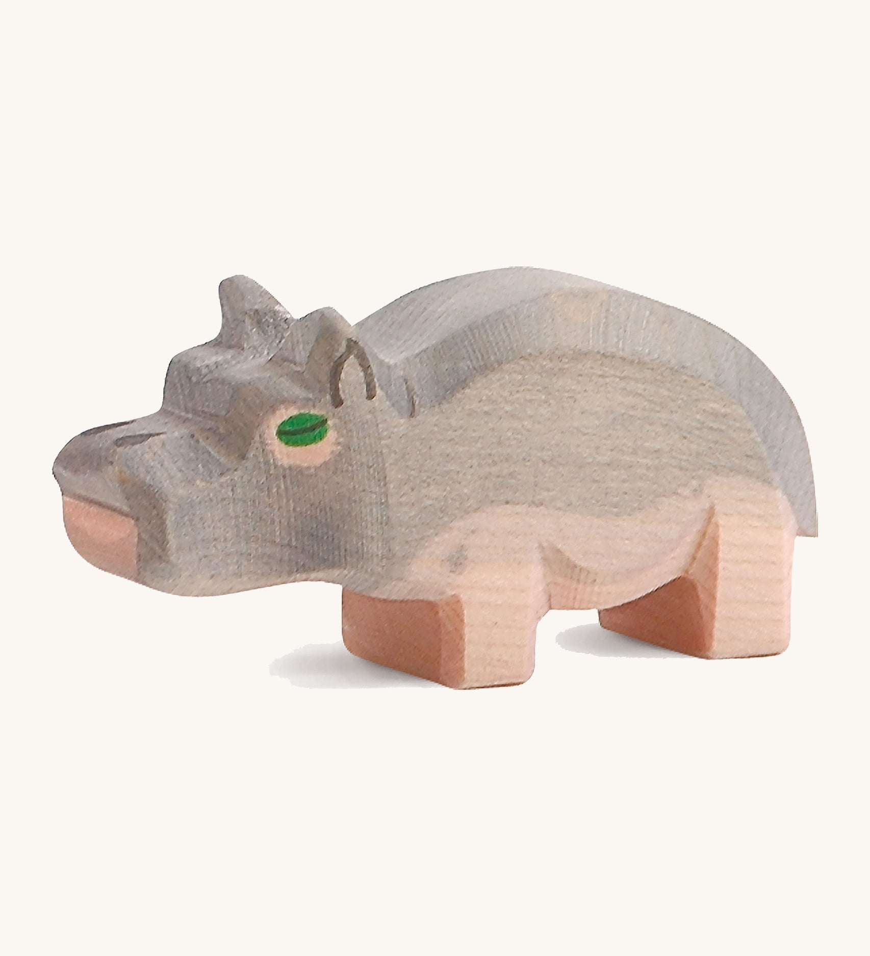 A small wooden Ostheimer hippo figure on a cream backround.