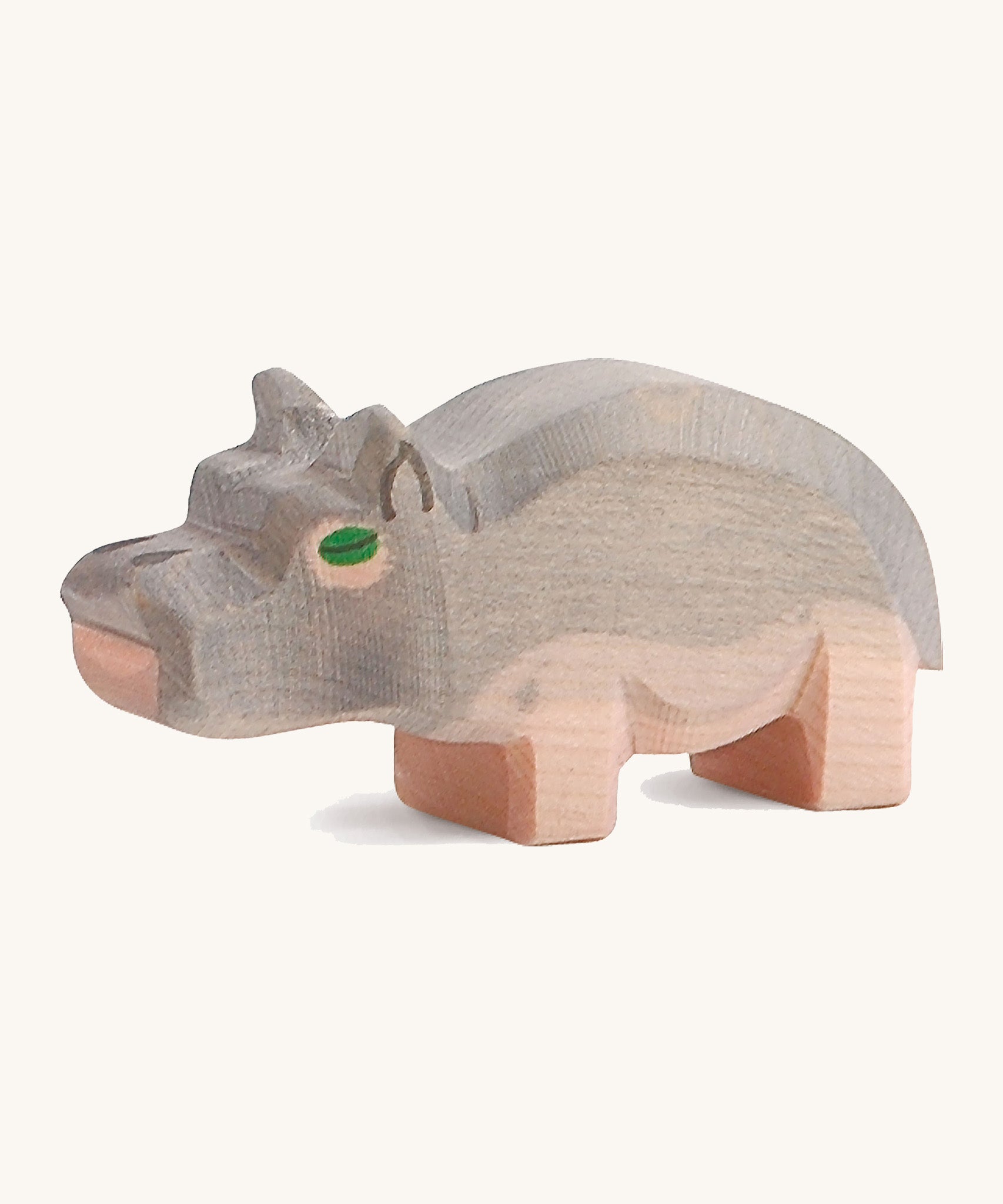 A small wooden Ostheimer hippo figure on a cream backround.