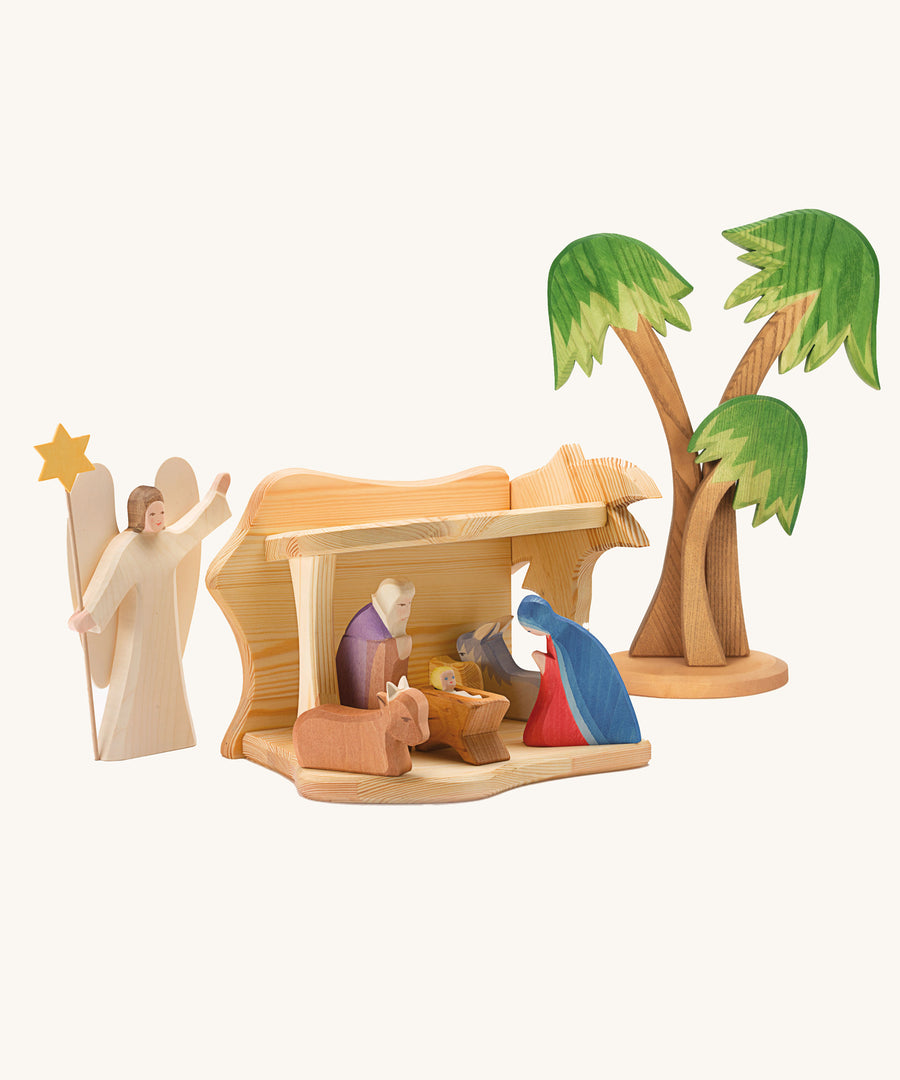 Ostheimer small wooden toy stable on a plain background. The stable has been filled and surrounded by Ostheimer nativity themed figures. 