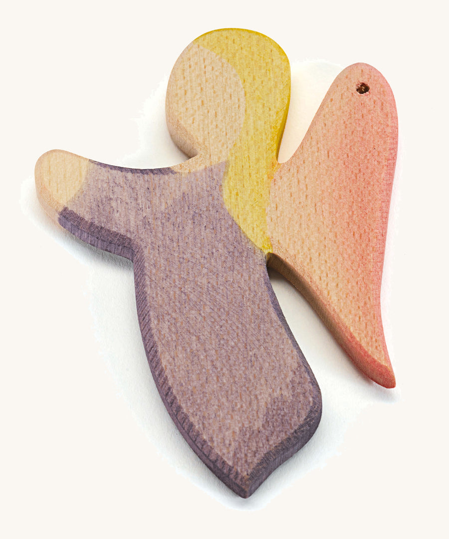 A wooden violet angel figure on a cream background