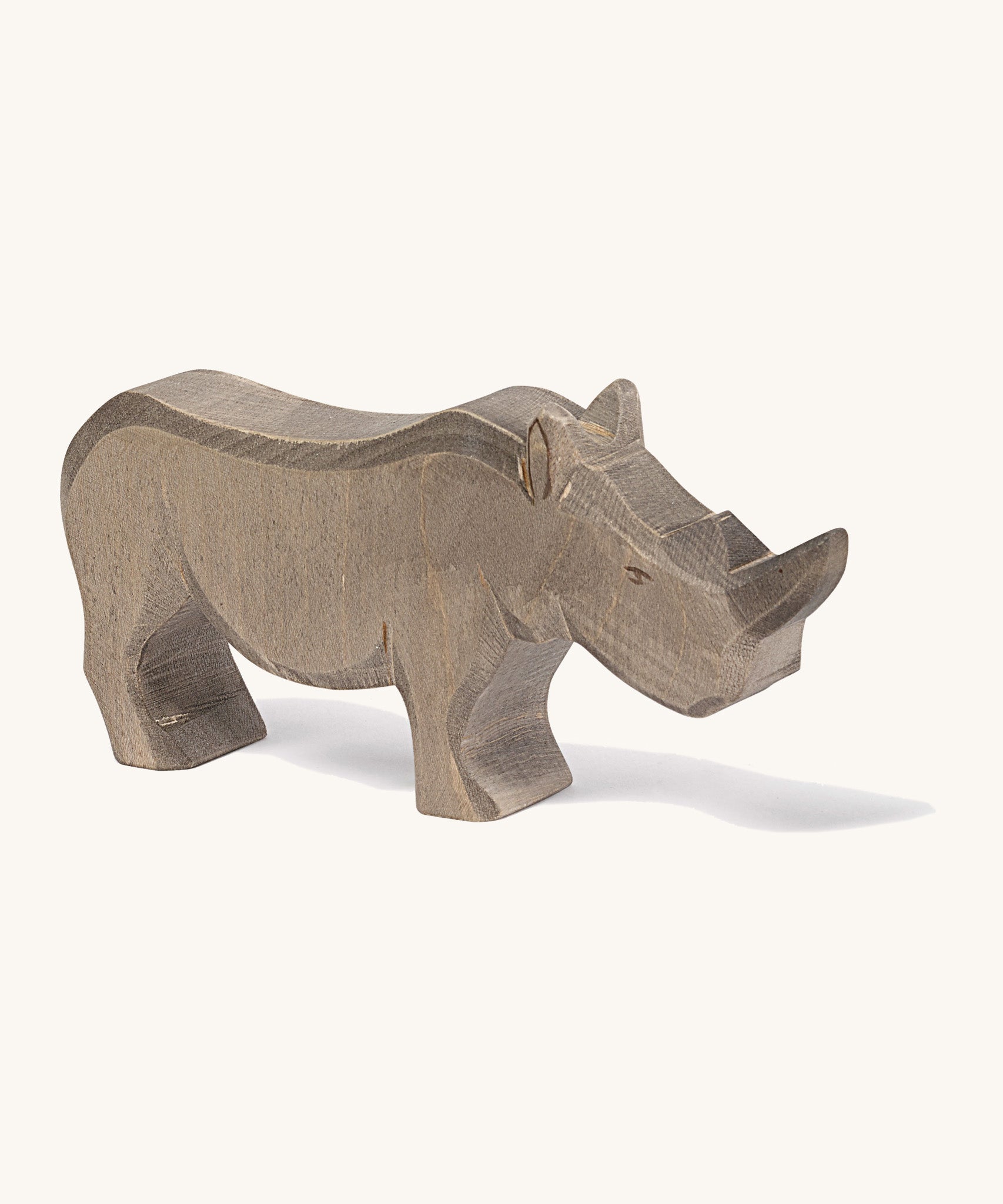 A wooden adult Ostheimer rhino figure on a cream background.