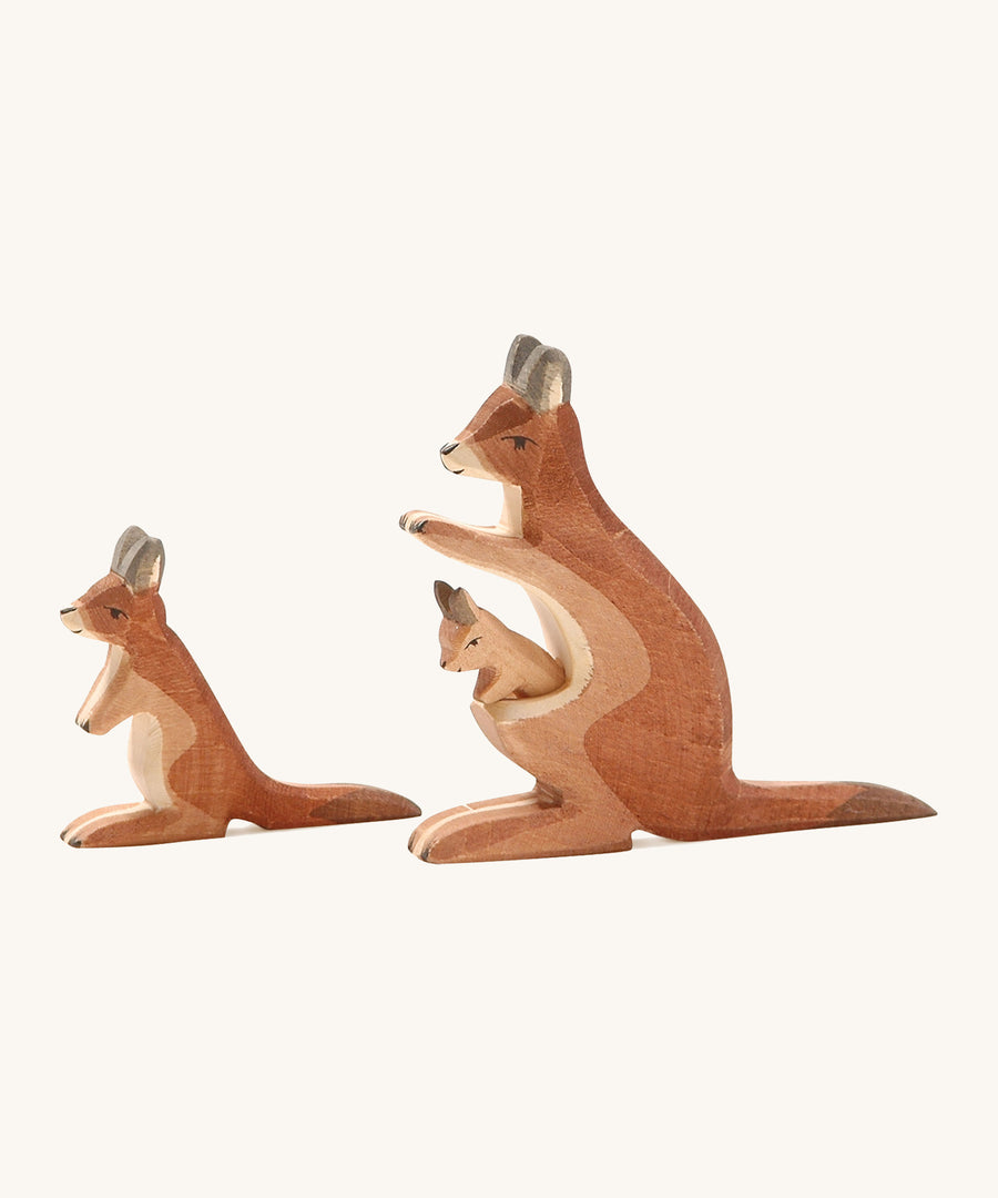 A wooden adult and small Ostheimer kangaroo on a cream background.