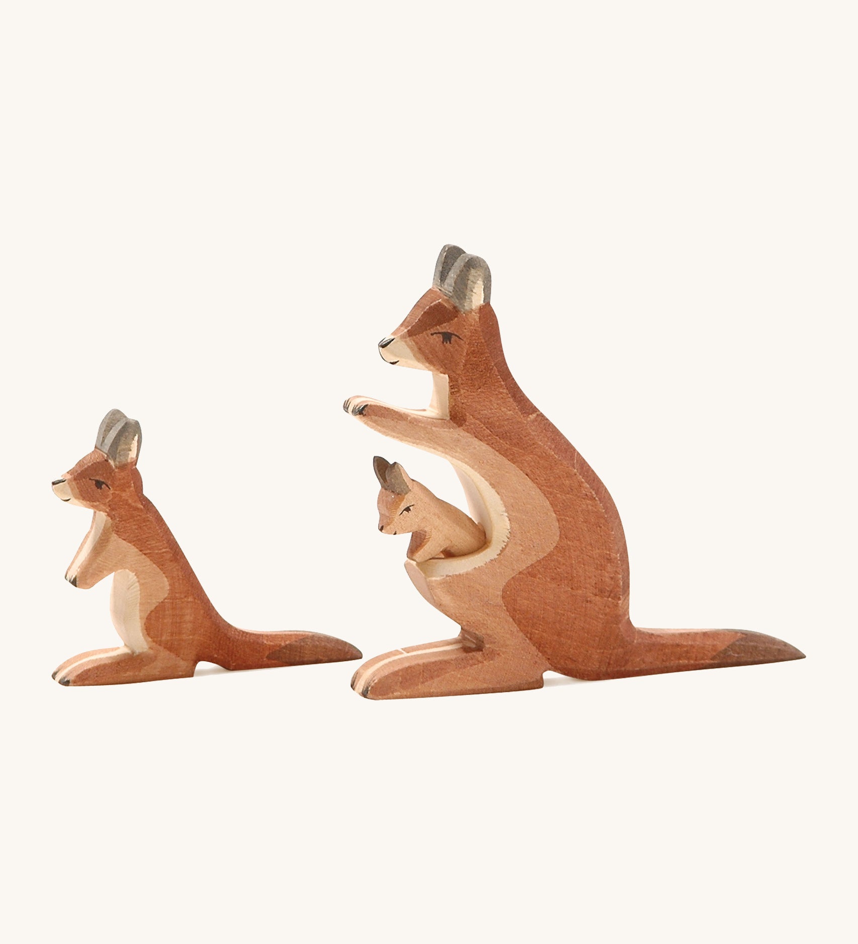 A wooden adult and small Ostheimer kangaroo on a cream background.