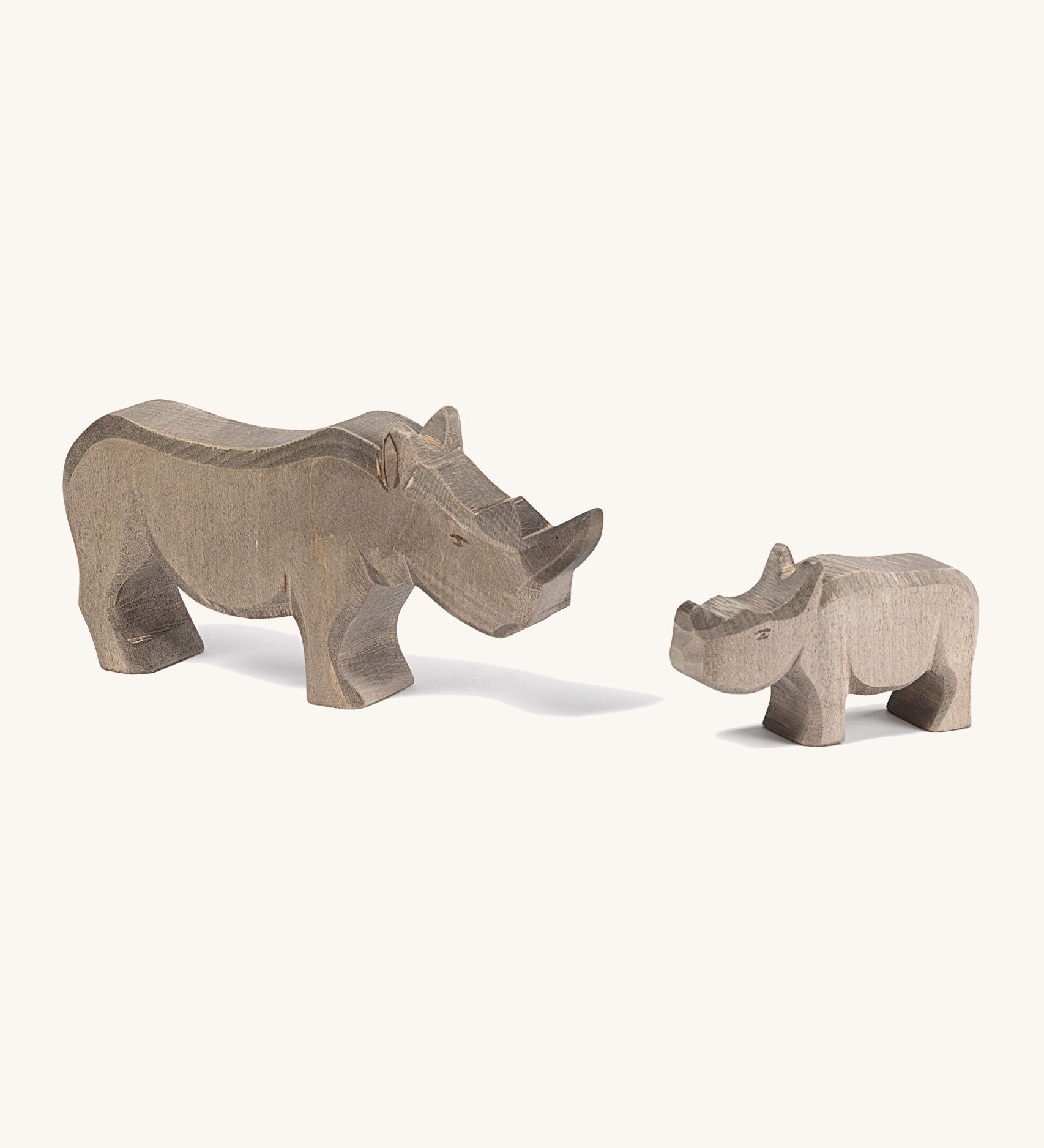 Wooden adult and baby Ostheimer figures on a cream background.