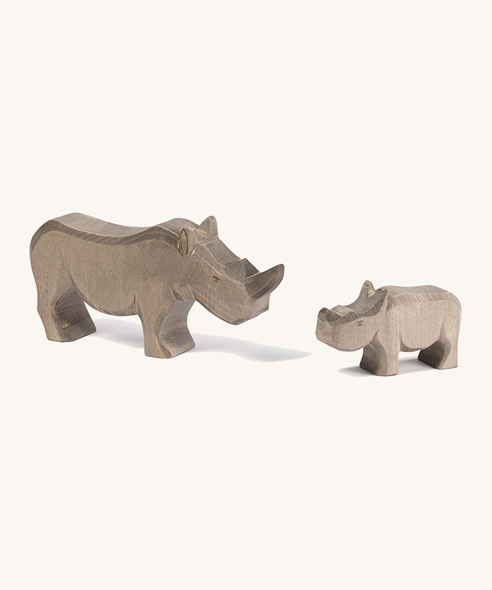 Wooden adult and baby Ostheimer figures on a cream background.