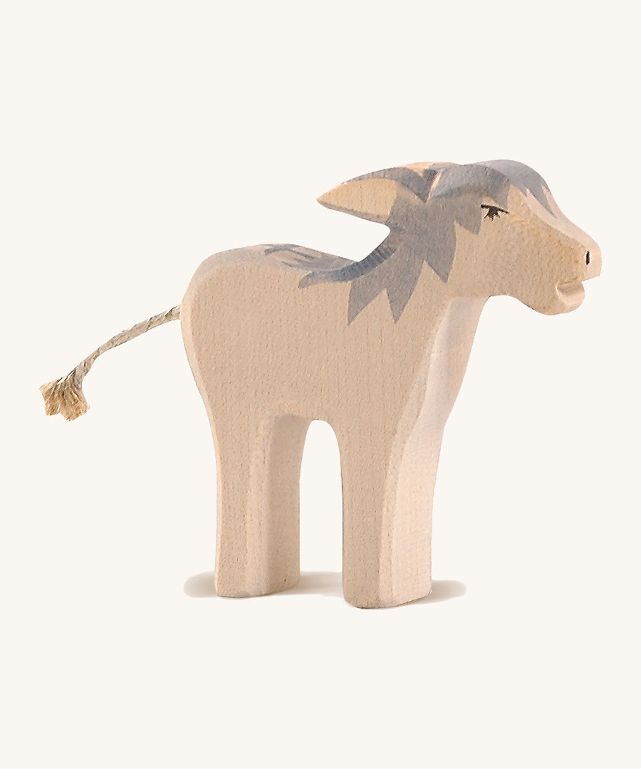 A wooden Ostheimer angry standing donkey on a cream background.