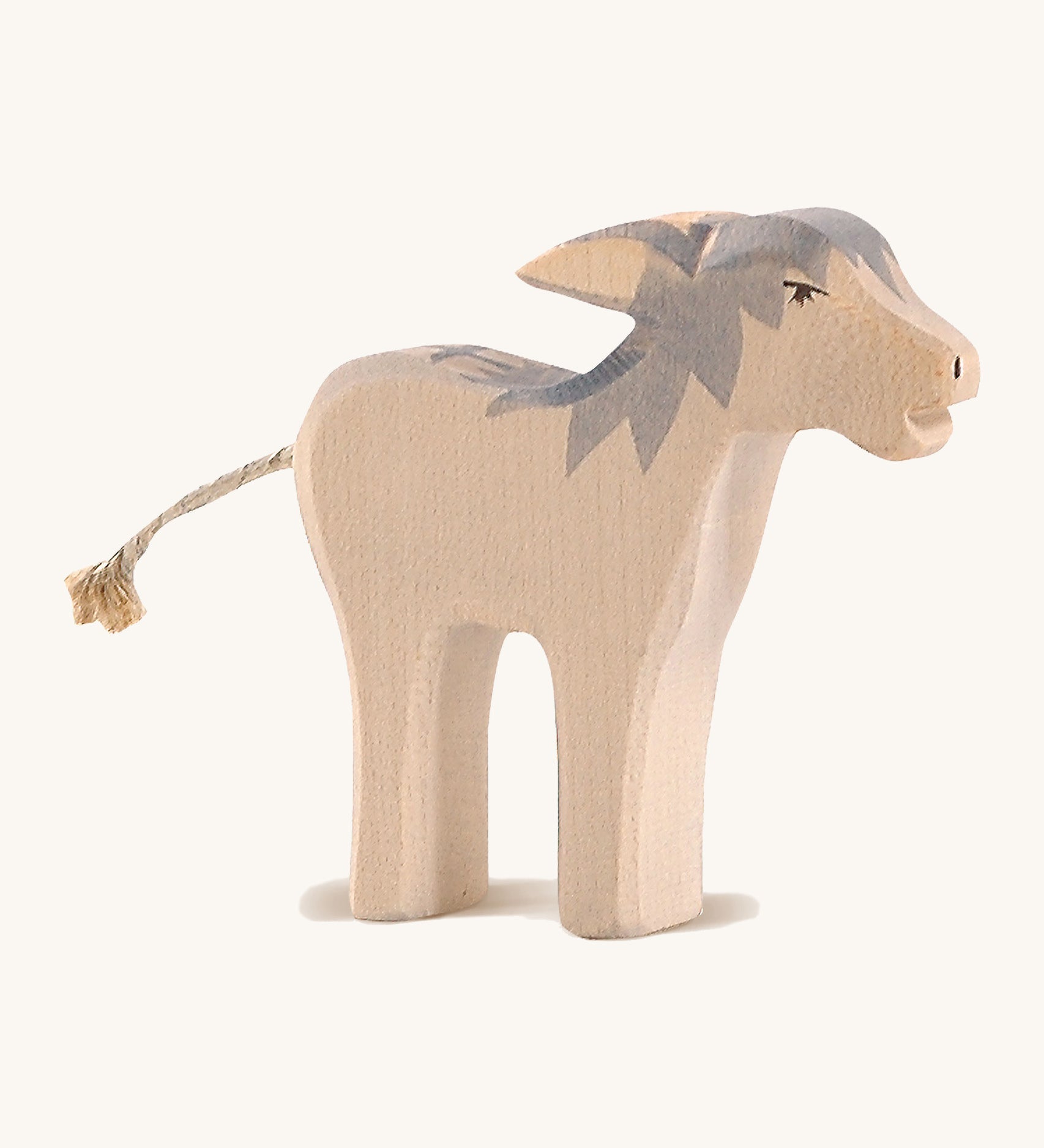 A wooden Ostheimer angry standing donkey on a cream background.