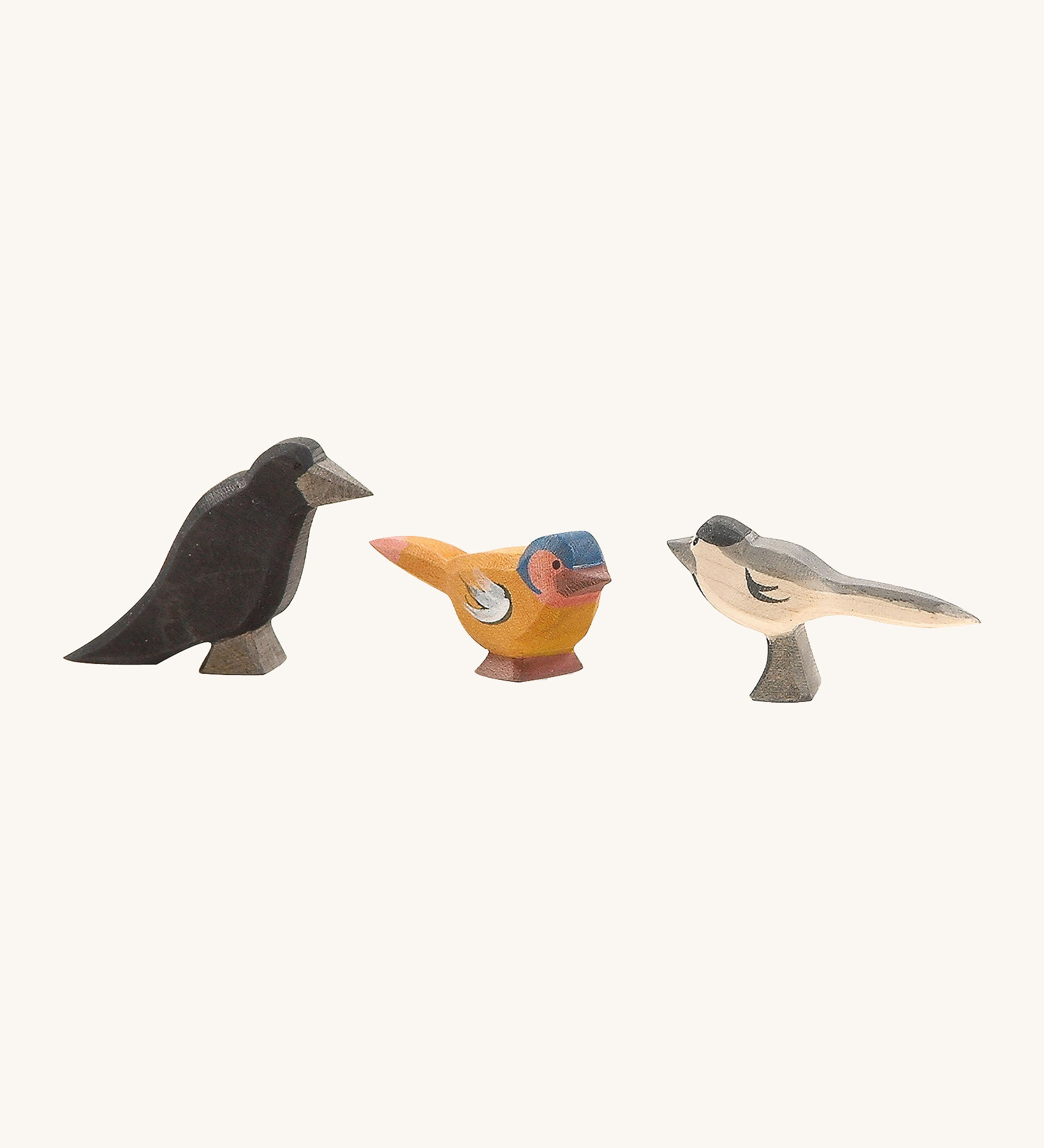 A raven, bullfinch and a magpie Ostheimer figure on a cream background.